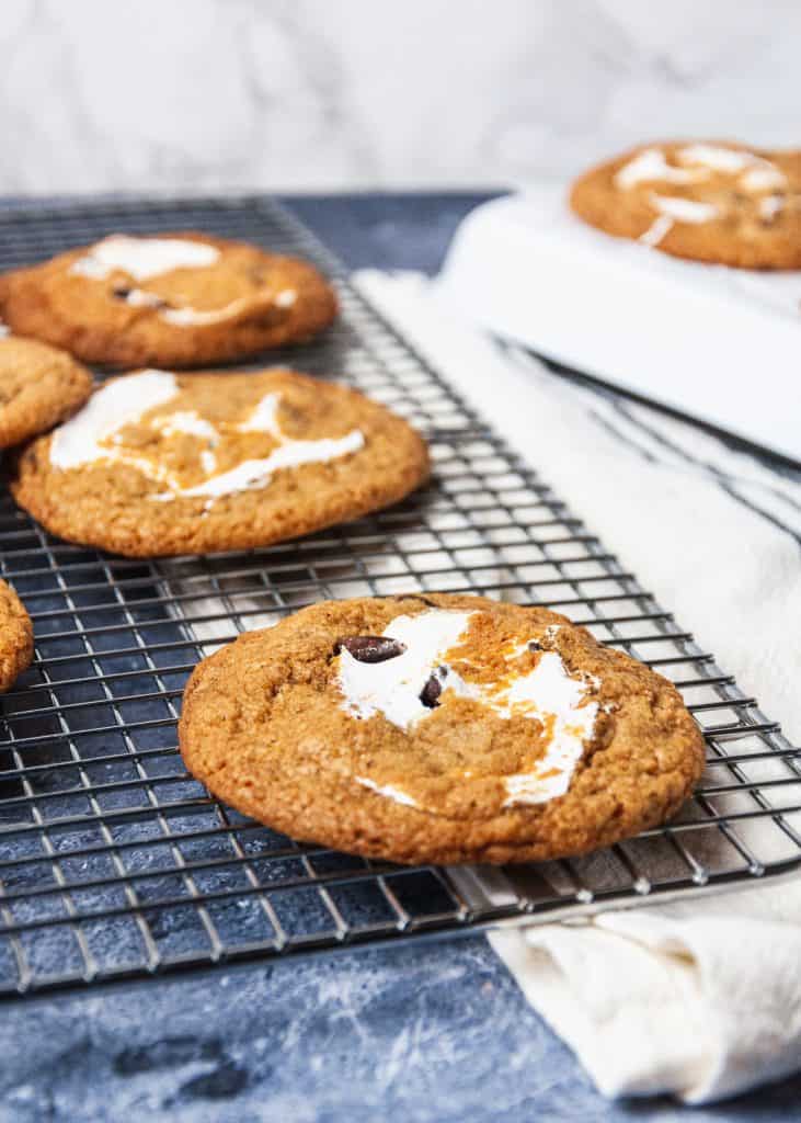 s'mores chocolate chip cookies stuffed with marshmallow fluff cooling on rack