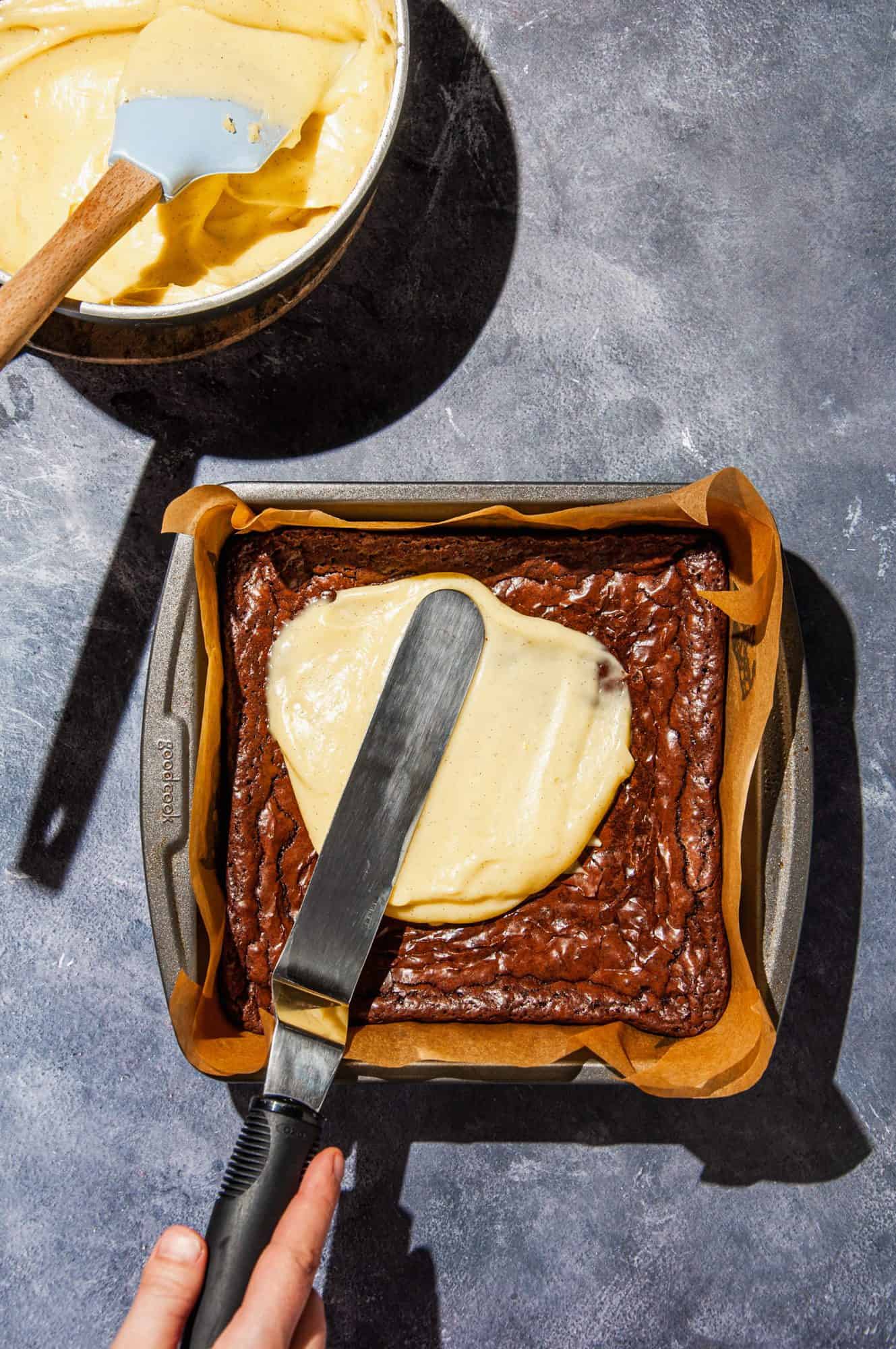 spreading creme brulee topping on top of baked, cooled brownies