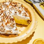 lemon meringue pie with bruleed top with a slice taken out