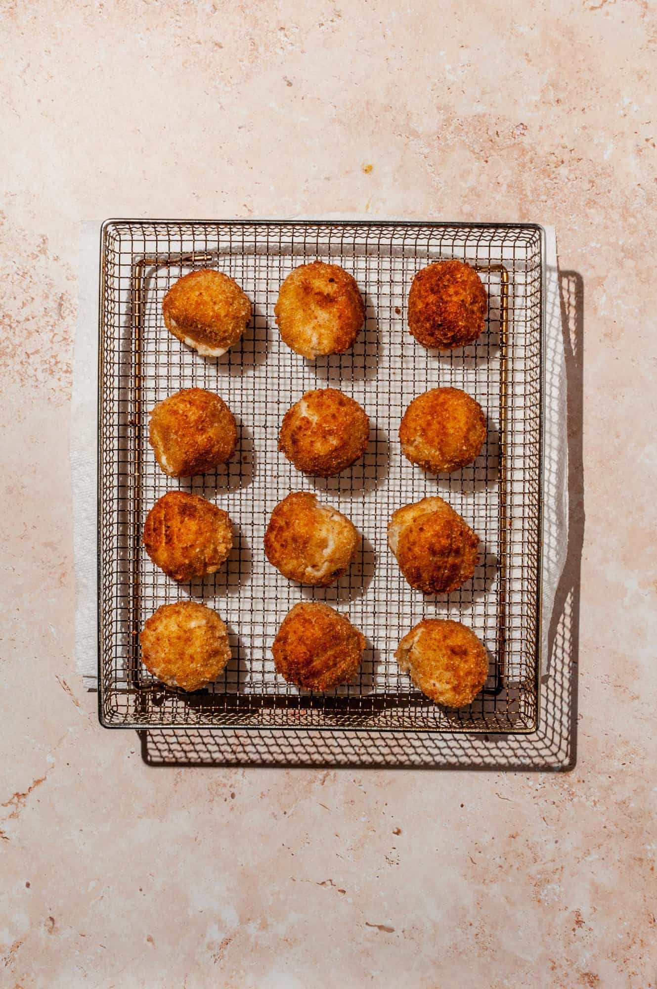 cooked ham and cheese croquettes on an air fryer tray 