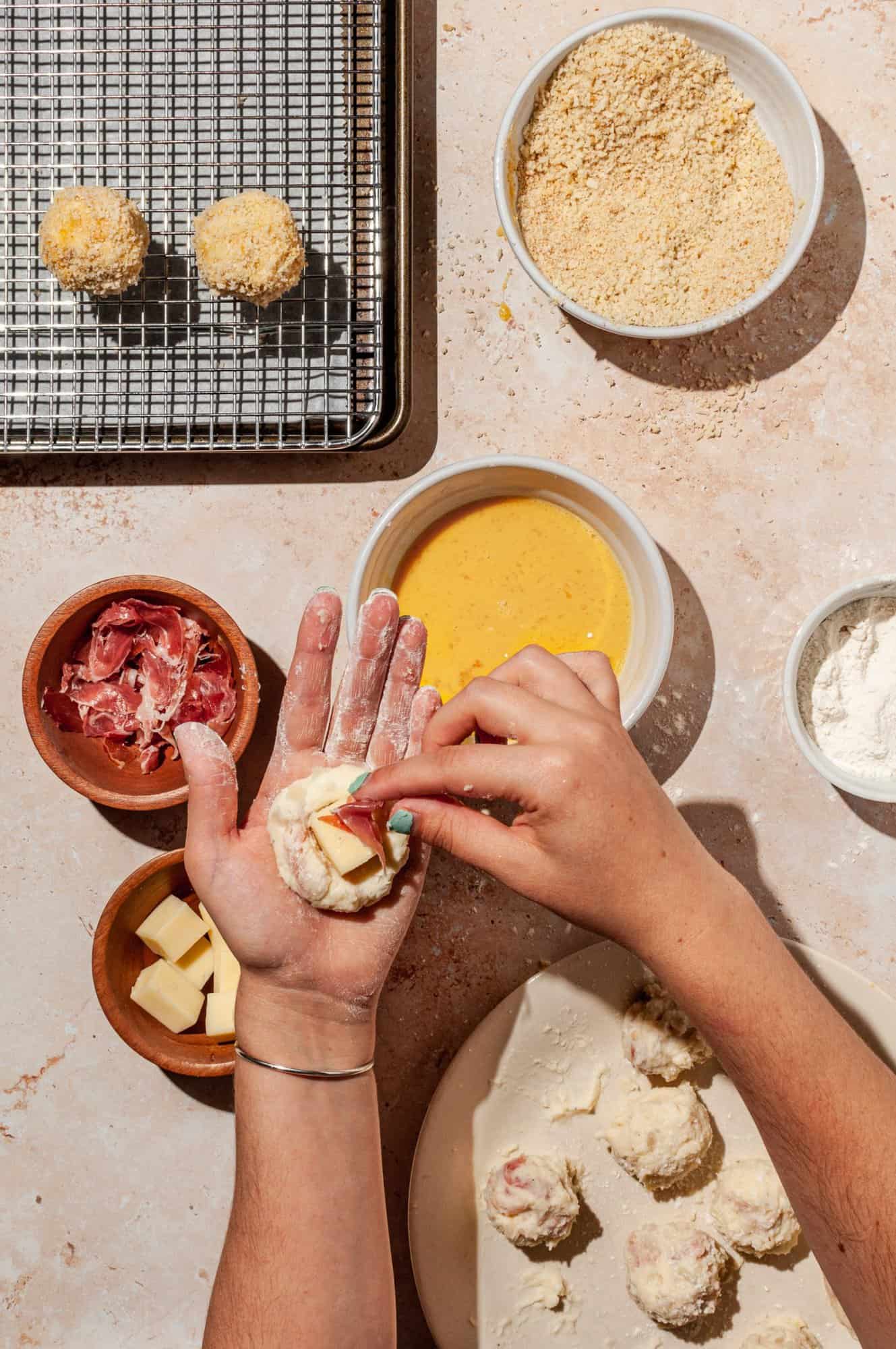 stuffing croquettes with a cube of cheese and diced cured ham