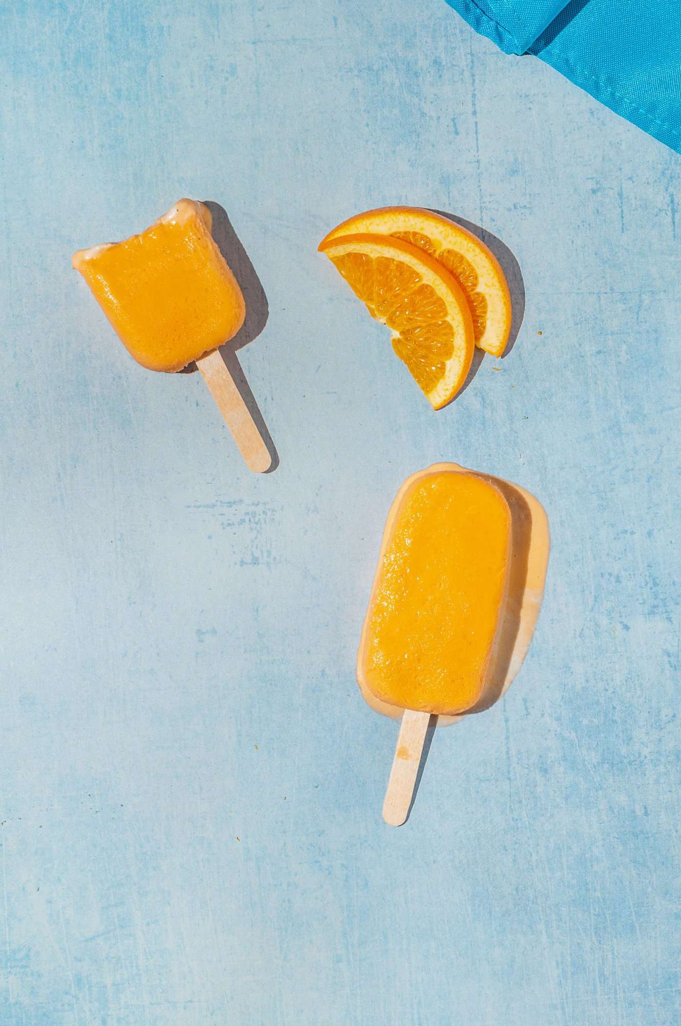 orange creamsicle melting, half eaten popsicle to the side