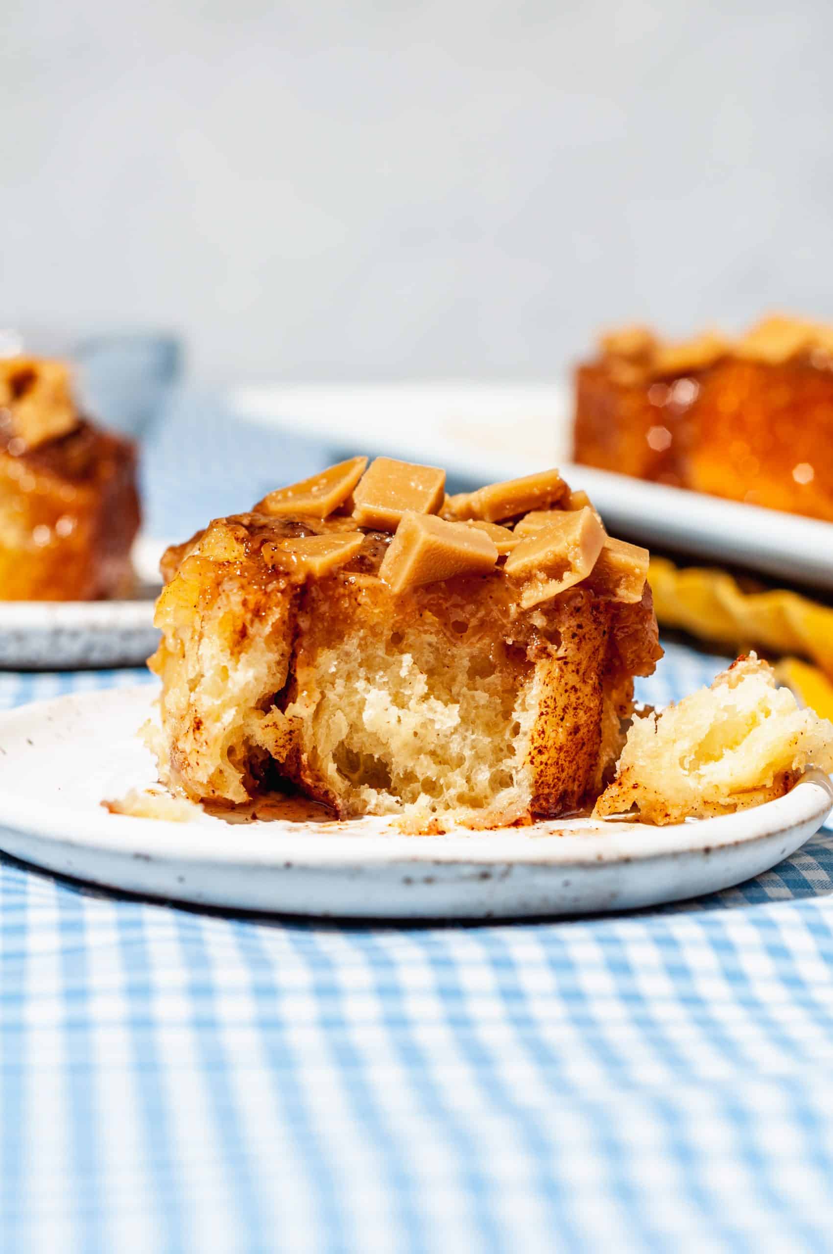 sticky toffee bun on a plate with a bite out