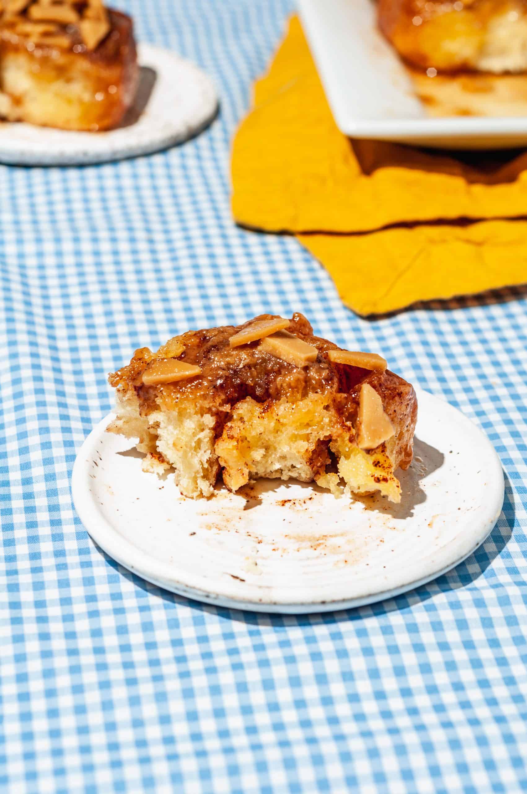 half-eaten sticky toffee bun on a plate showing inside