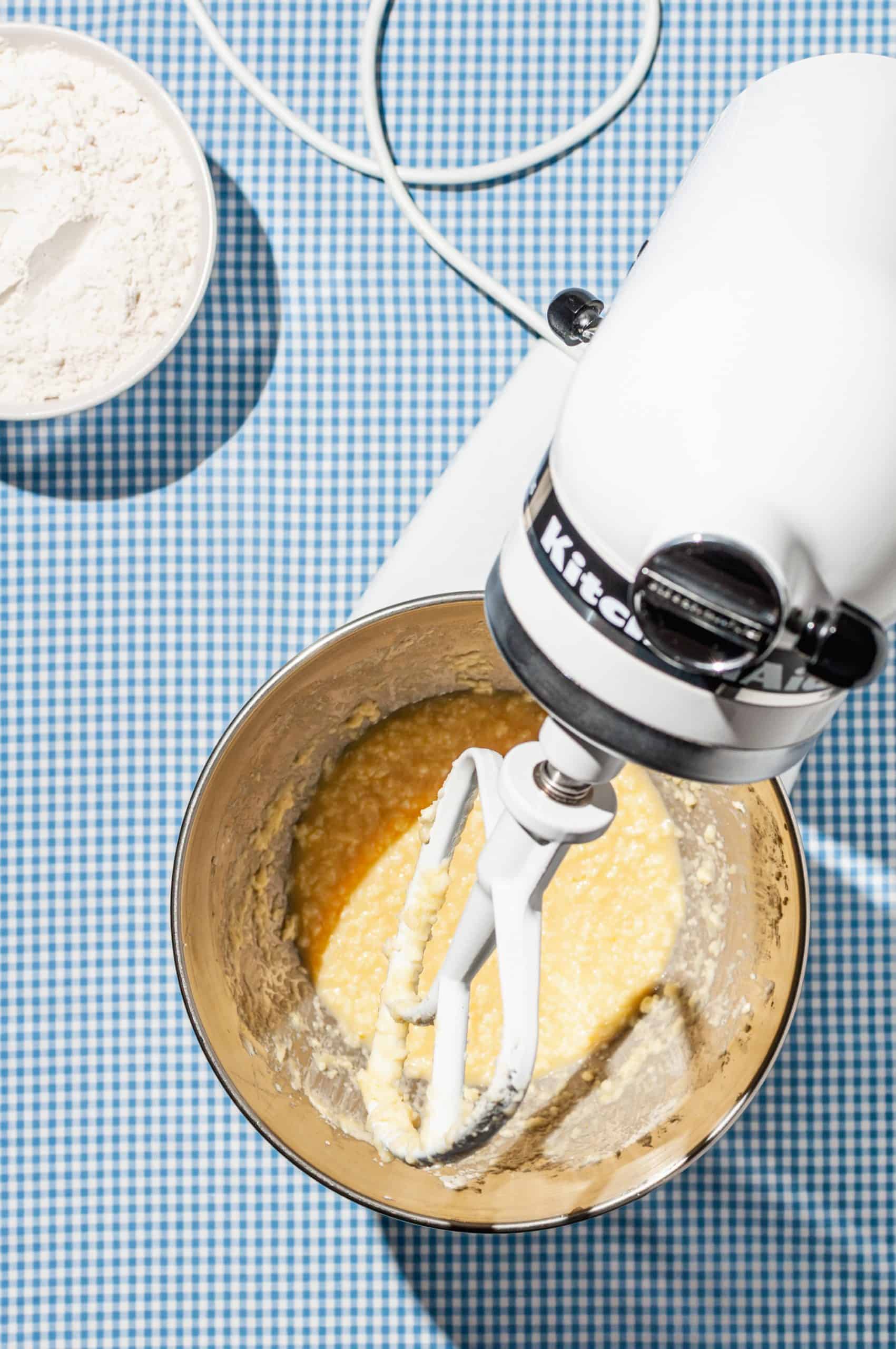 bowl of stand mixer with yellow liquid mixture