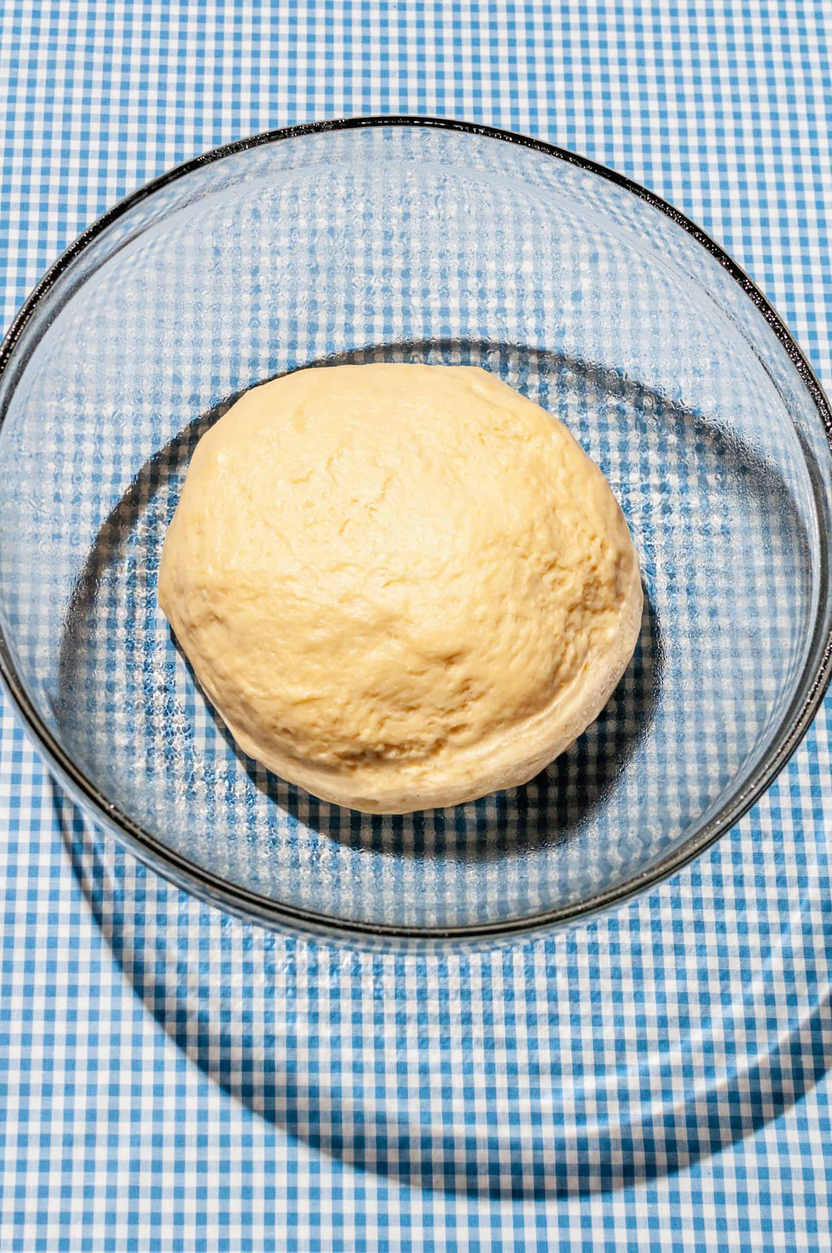 ball of sticky bun dough in a glass bowl