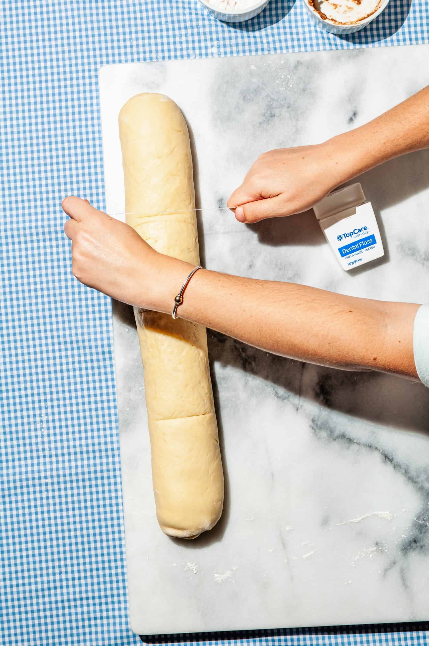 marking rolled log of dough into portions with floss indentations