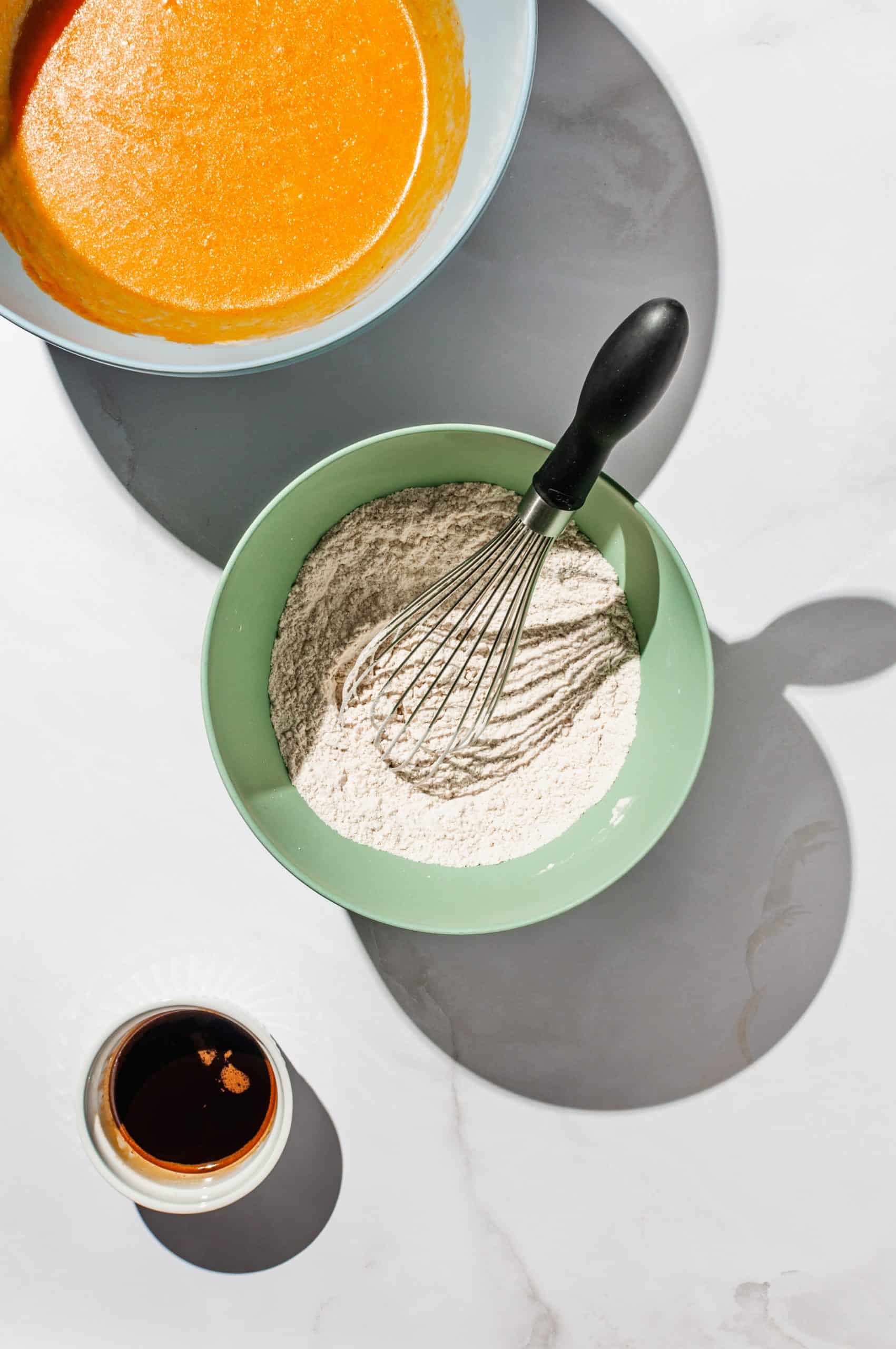 mixing bowl with flour, spices, and a whisk