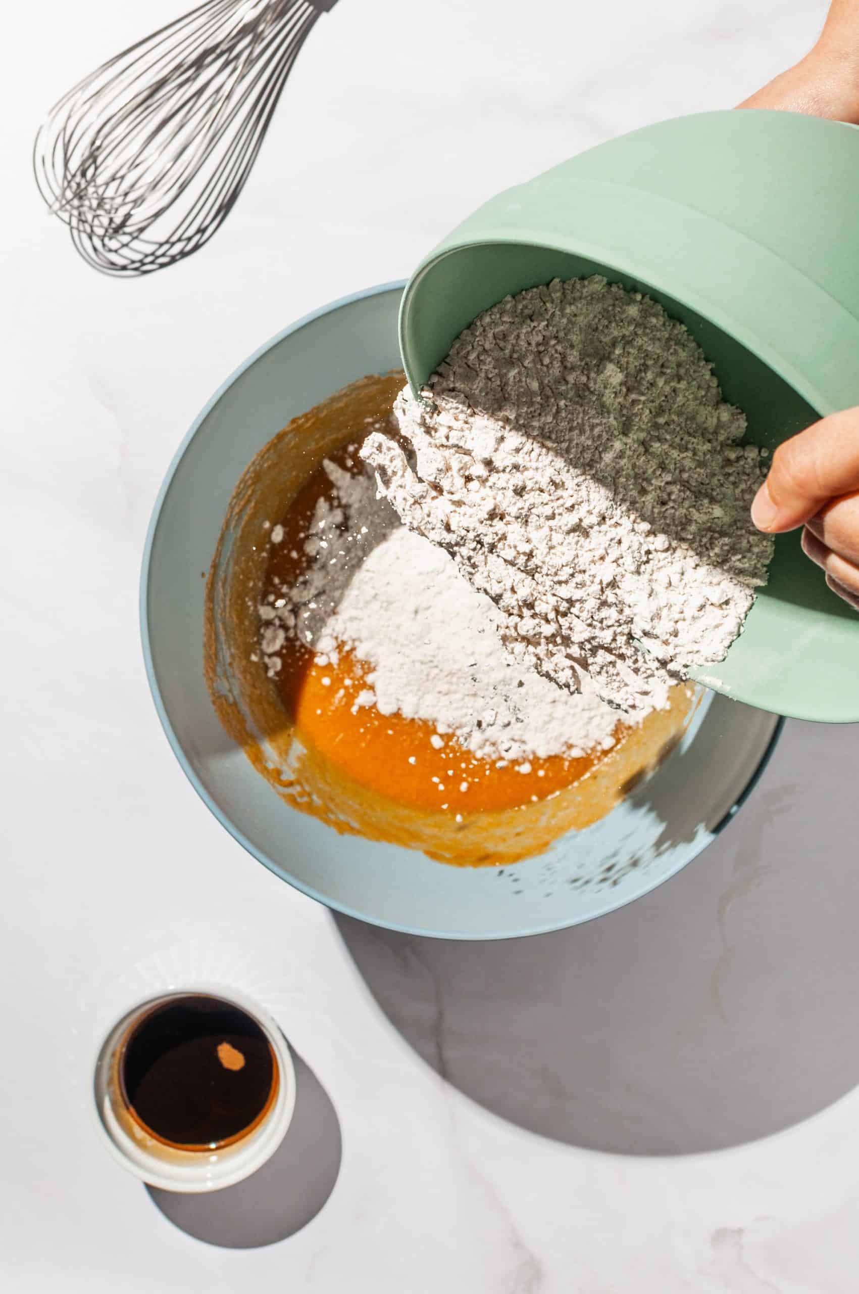 pouring flour mixture into pumpkin mixture