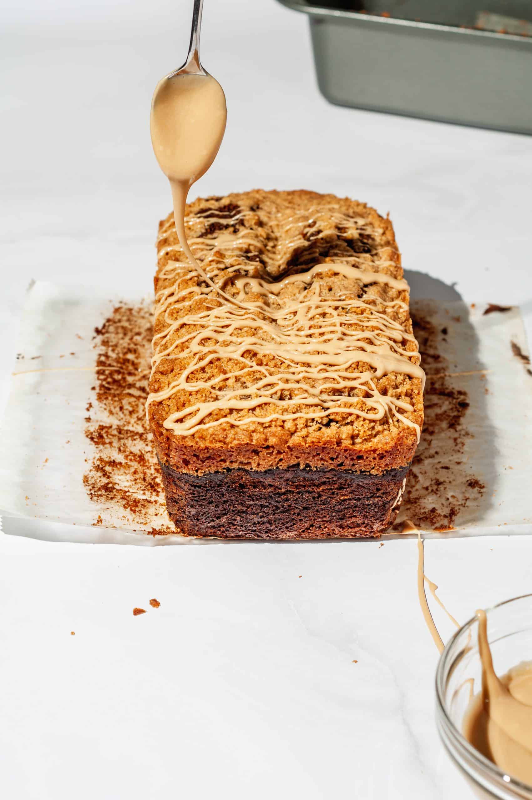 drizzling pumpkin spice latte loaf with maple coffee icing