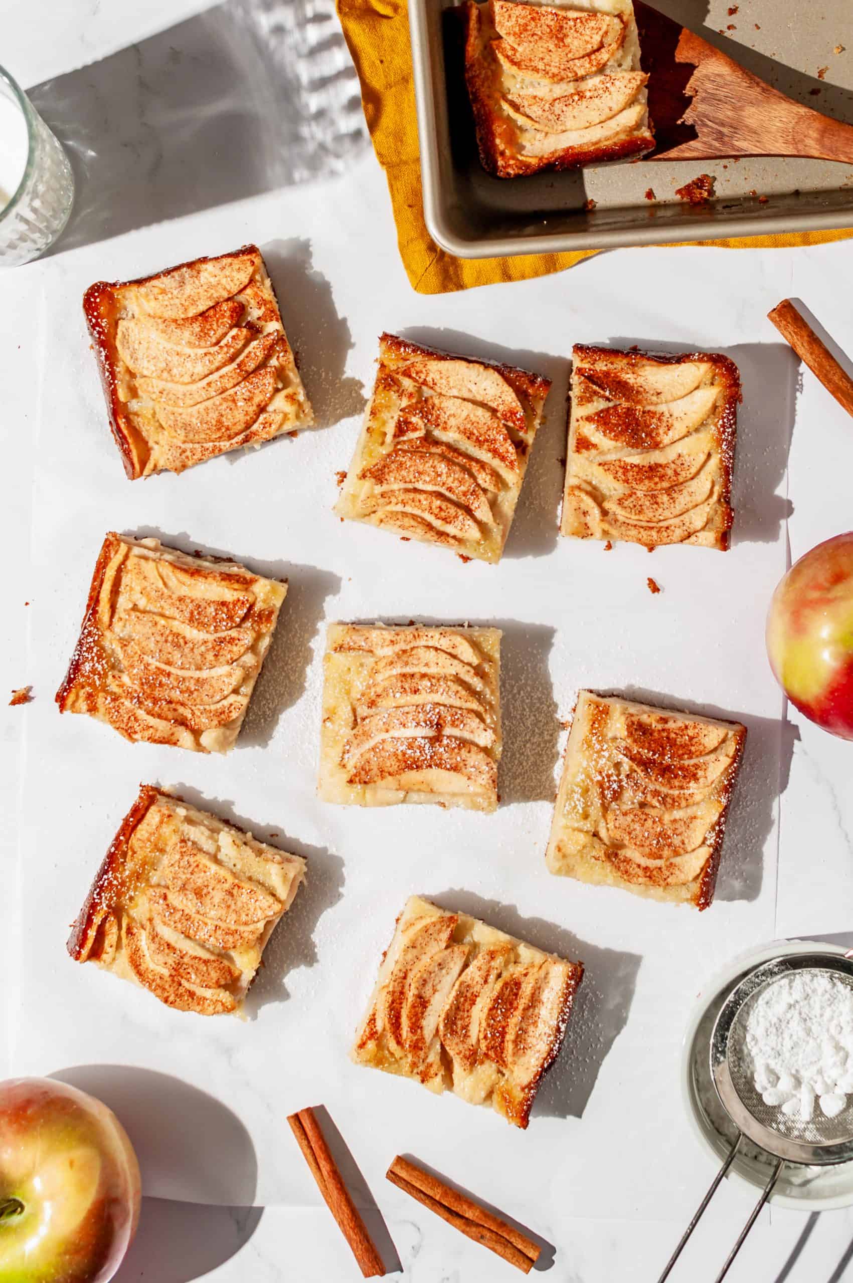 8 slices of apple snack cake spaced out on white parchment paper