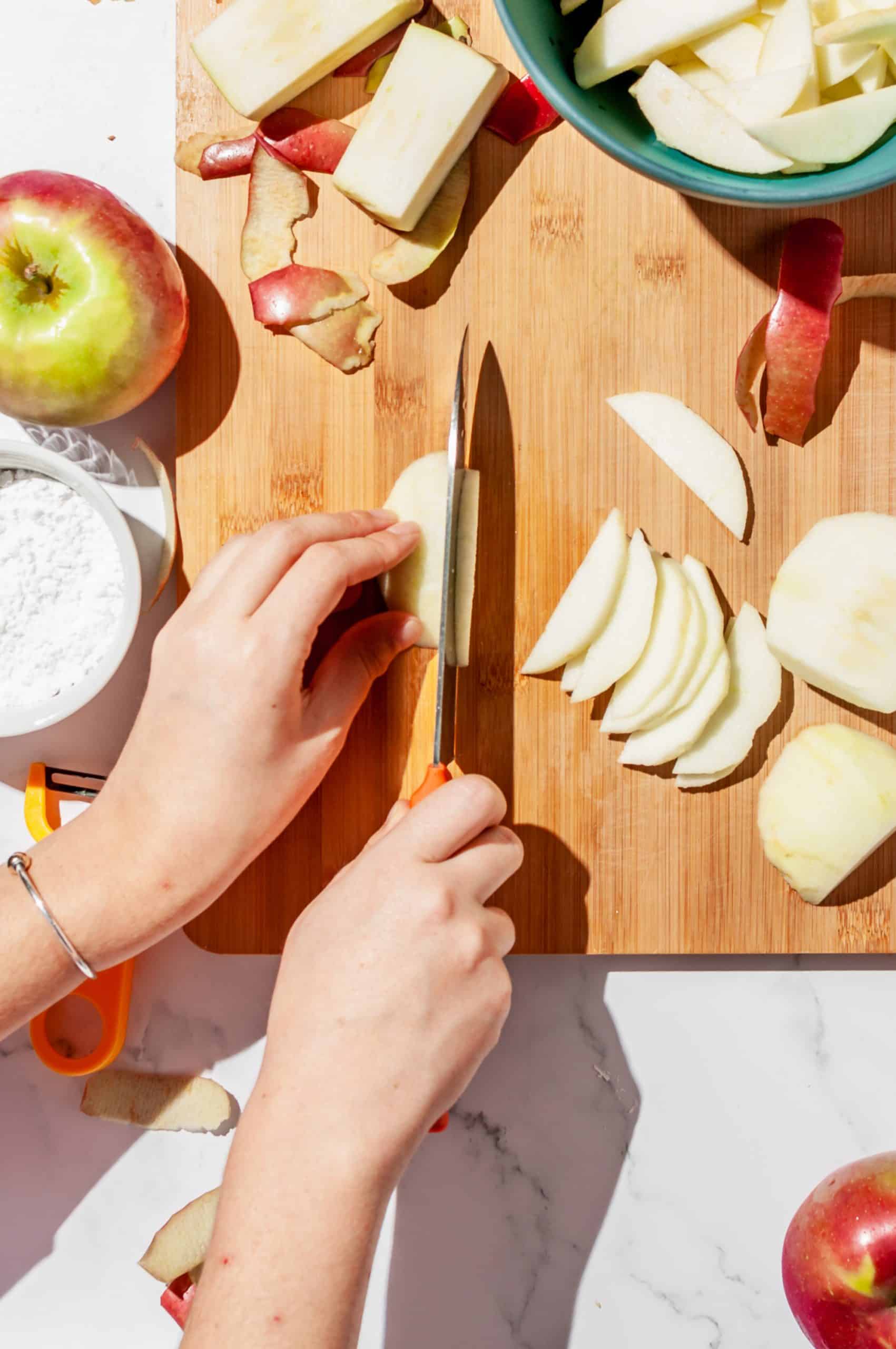 slicing apple section into thin slices, core and scraps to the side