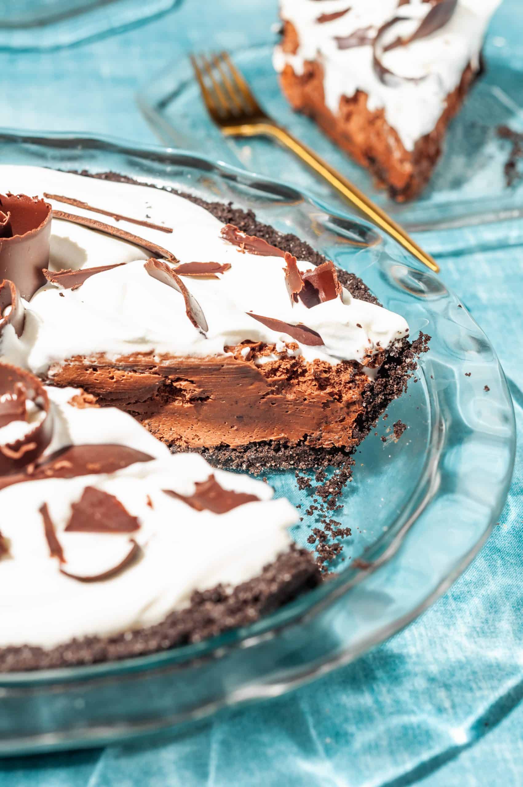 chocolate satin pie with a slice taken out showing creamy chocolate filling and oreo crust