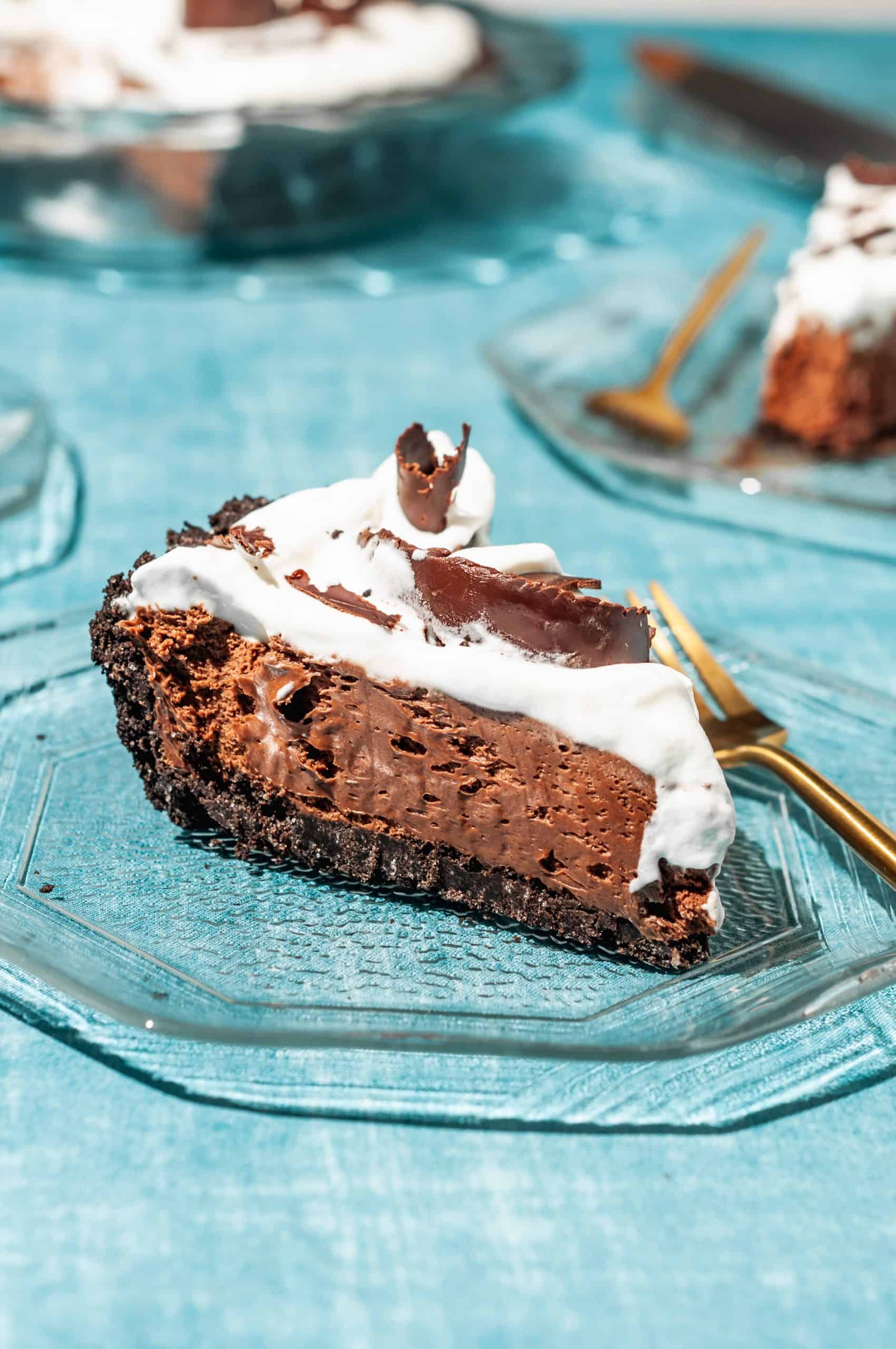 a slice of chocolate satin pie with oreo crust and whipped cream