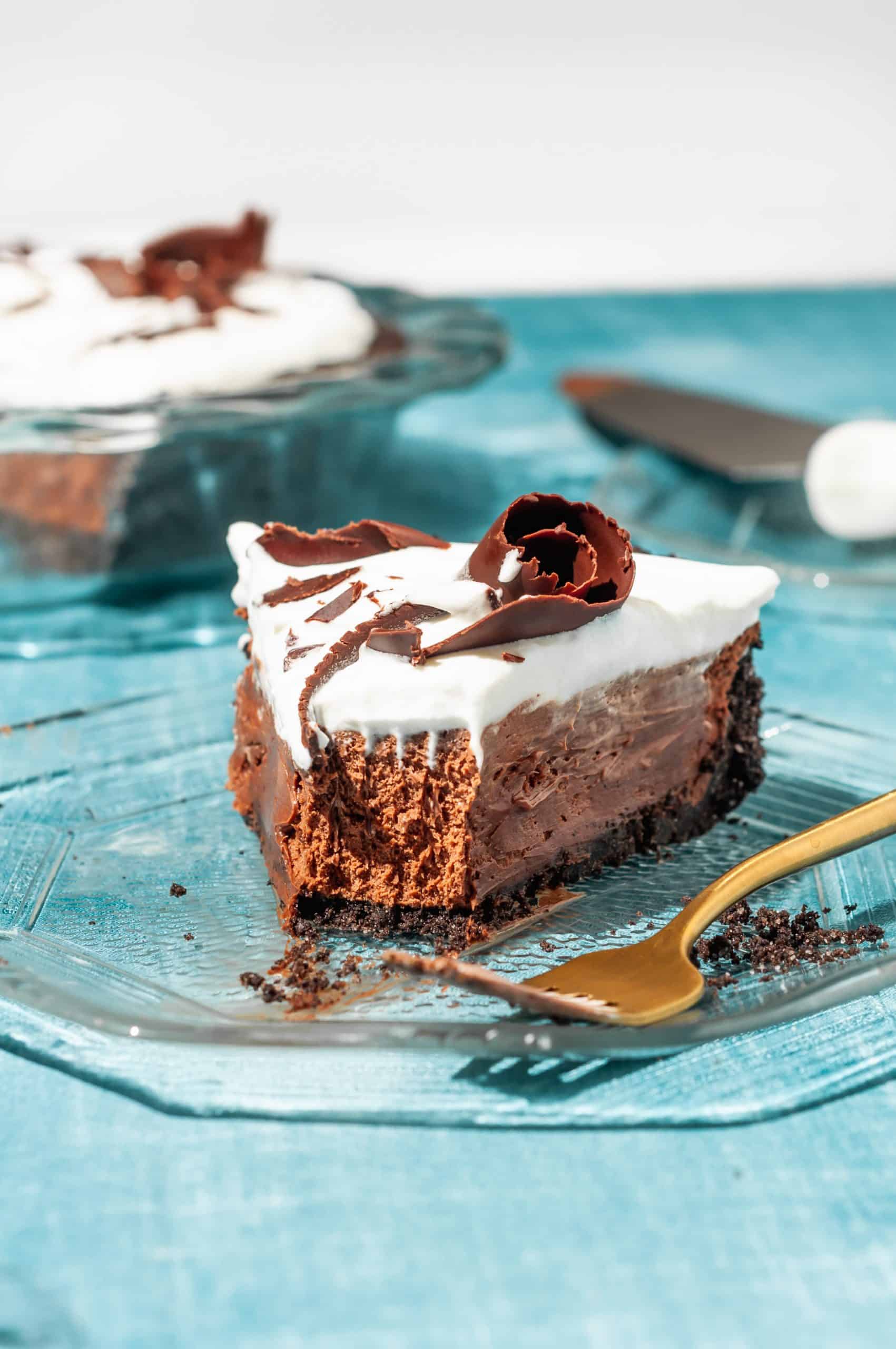 a slice of chocolate satin pie with oreo crust with a bite taken out with a fork