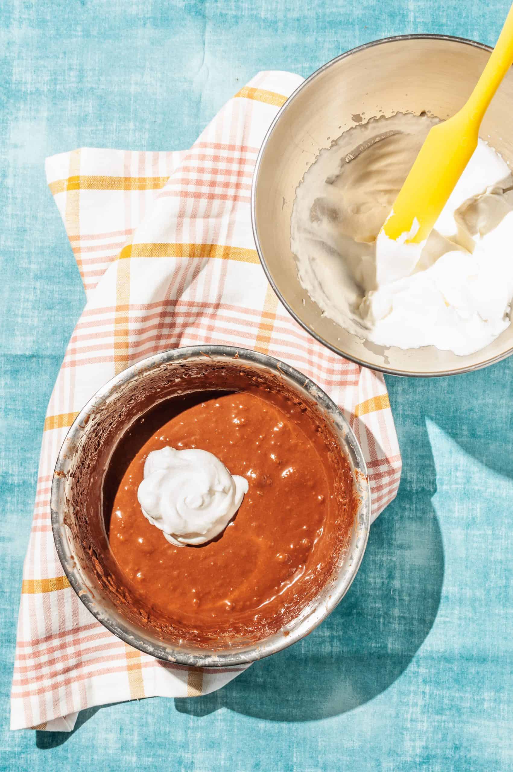 two bowls, one with whipped cream, one with melted chocolate mixture