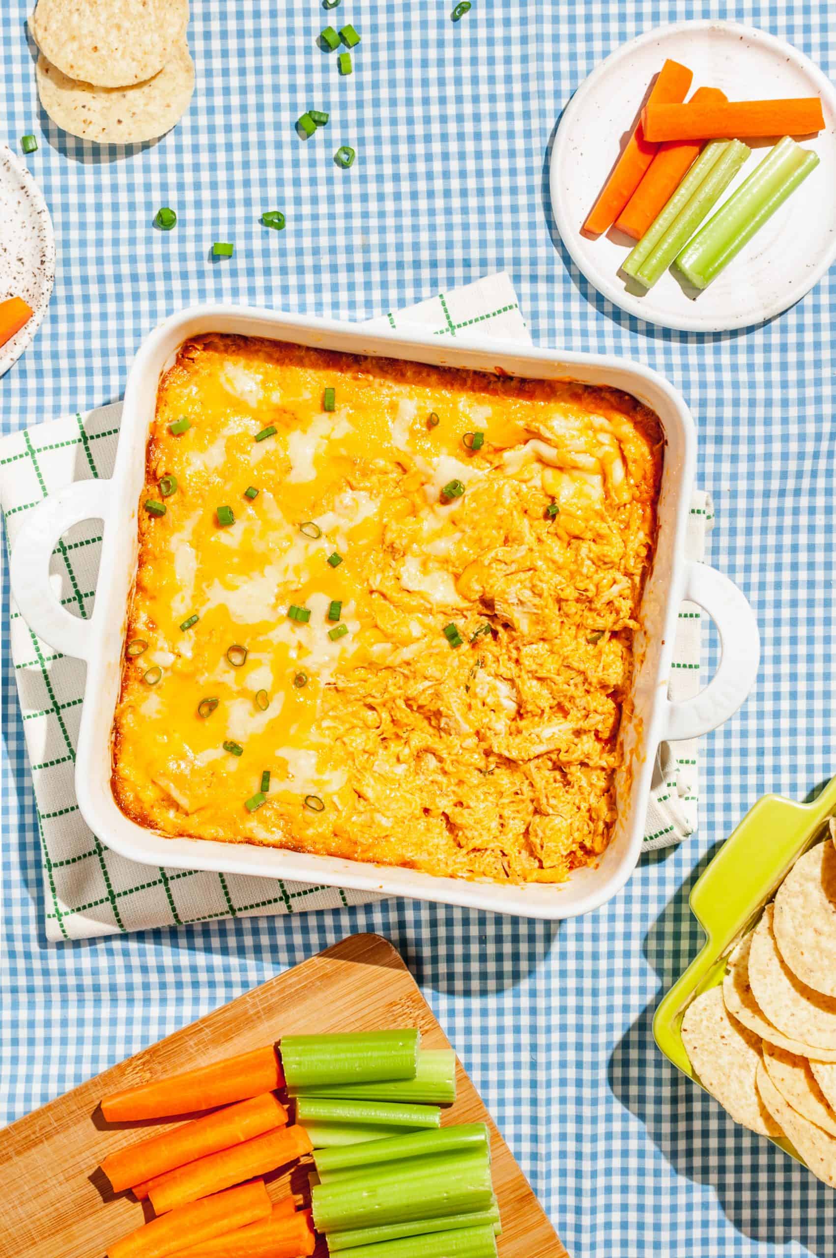 cheesy buffalo chicken dip in white baking dish on linen