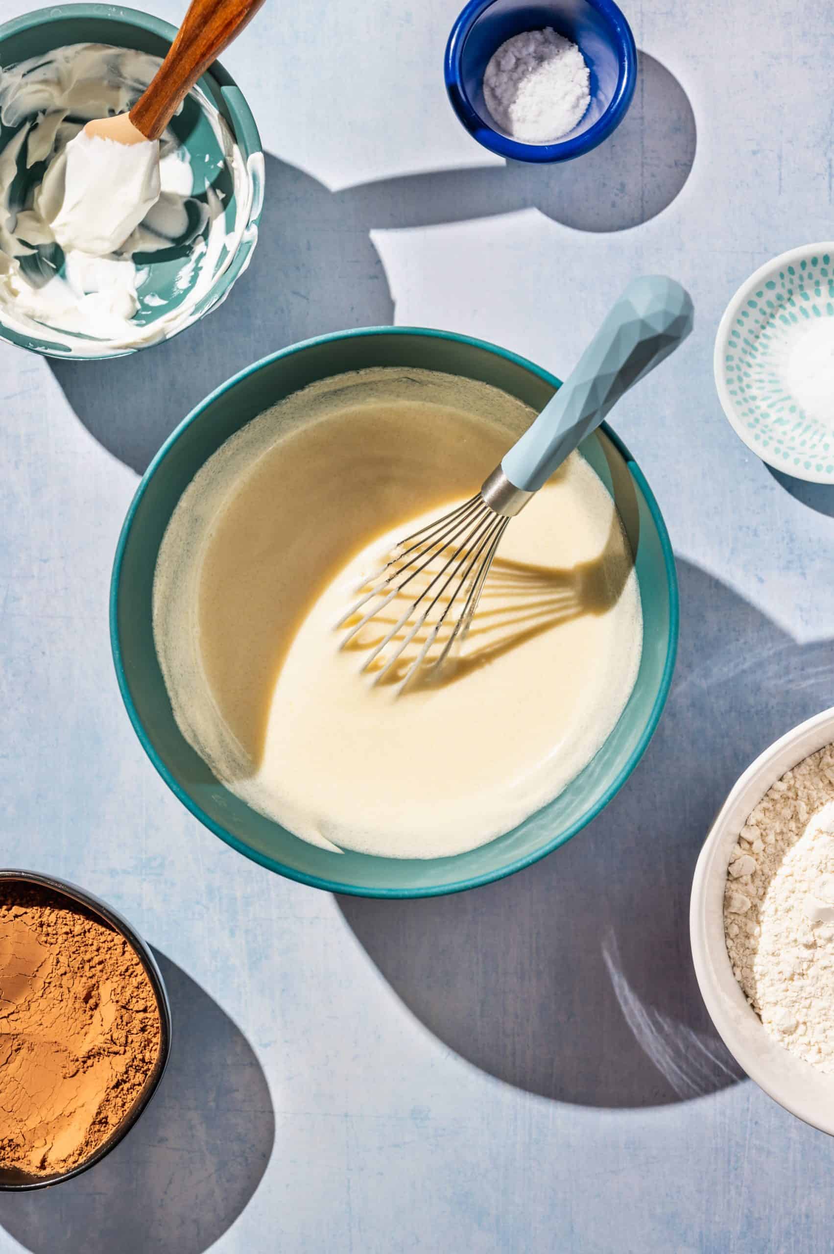 yellowish creamy mixture in a mixing bowl with a whisk