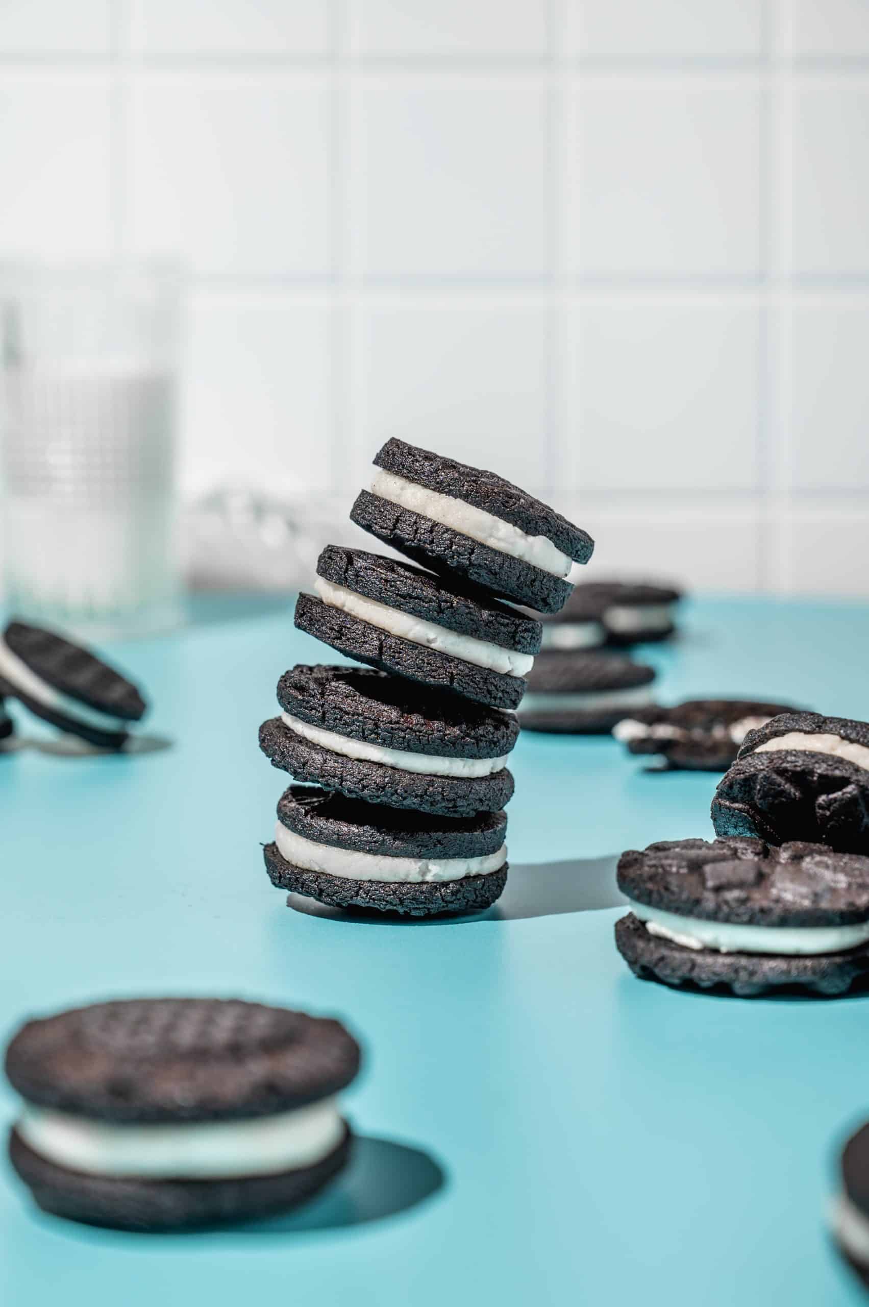 stack of 4 homemade Oreo cookies leaning to the right with extra oreos scattered around