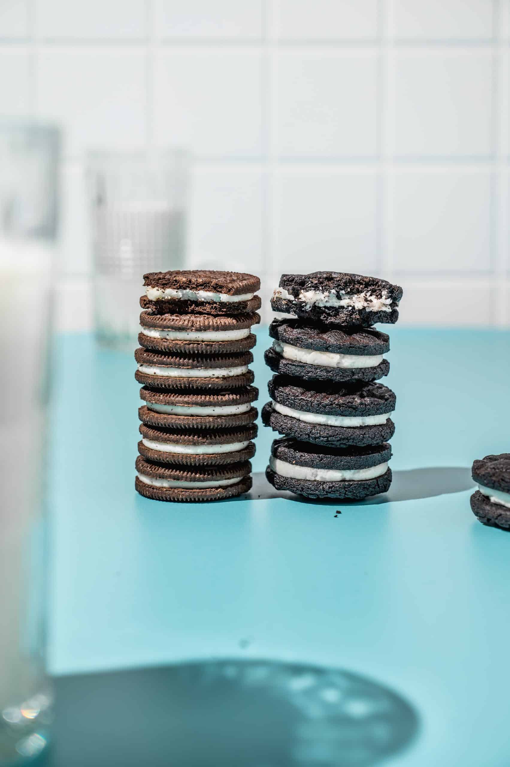 stack of 4 darker thicker homemade oreo cookies next to a stack of 6 commercial Oreos of the same height for comparison