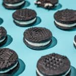 close up of homemade oreo cookies spaced in diagonal lines on a blue background