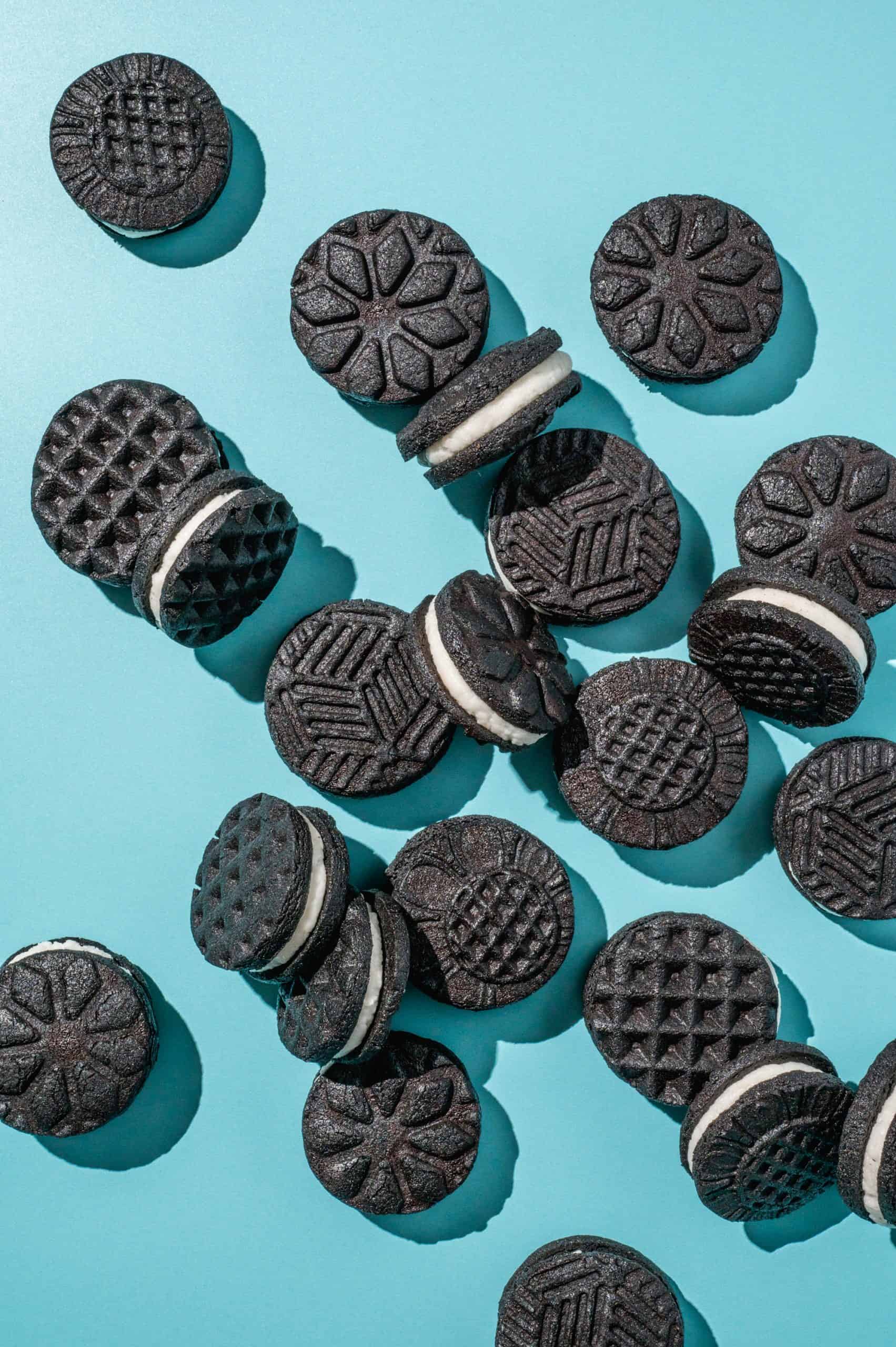 homemade oreo cookies with various stamped patterns on blue background