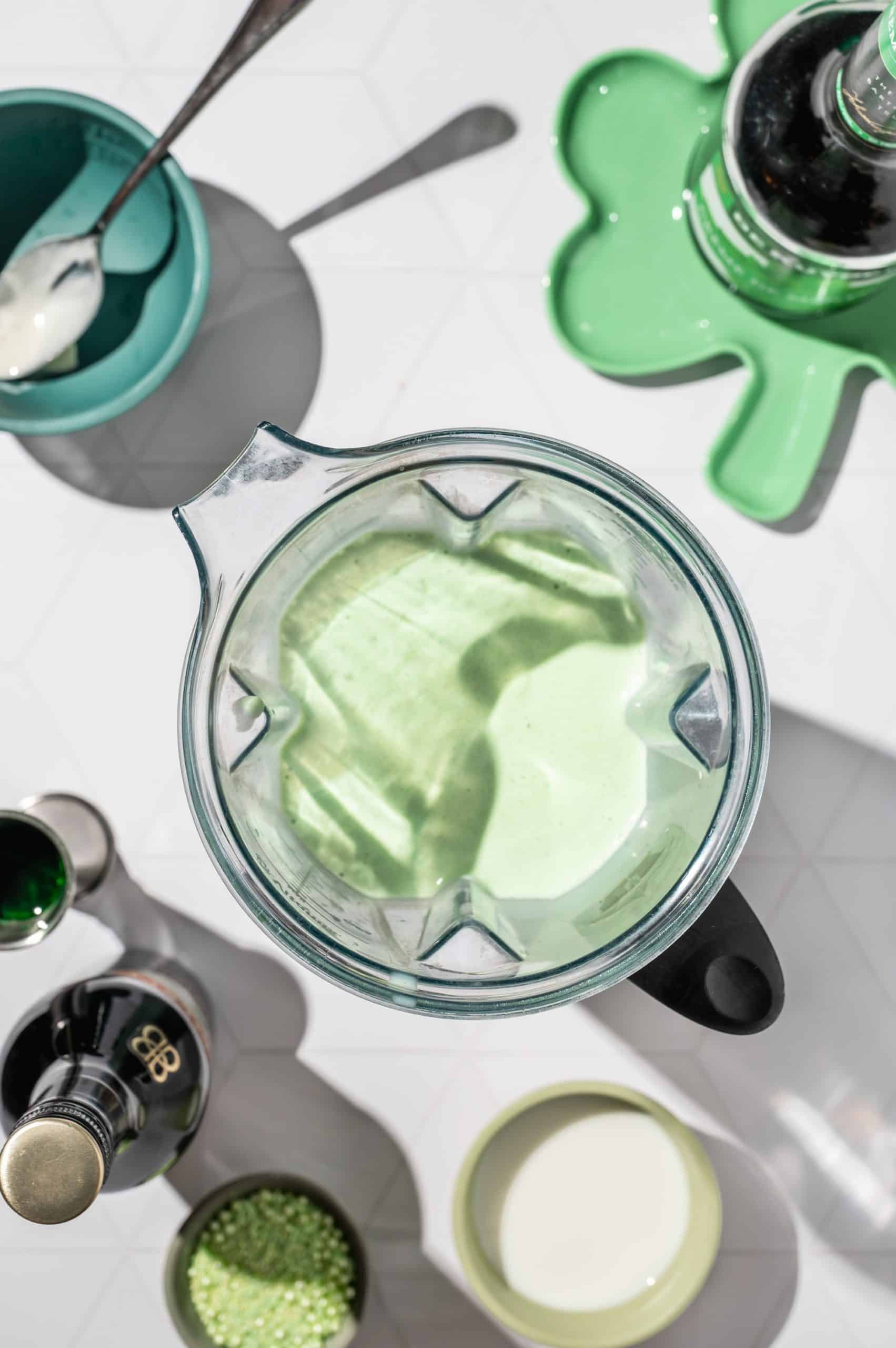 blender bowl filled with green mint milkshake