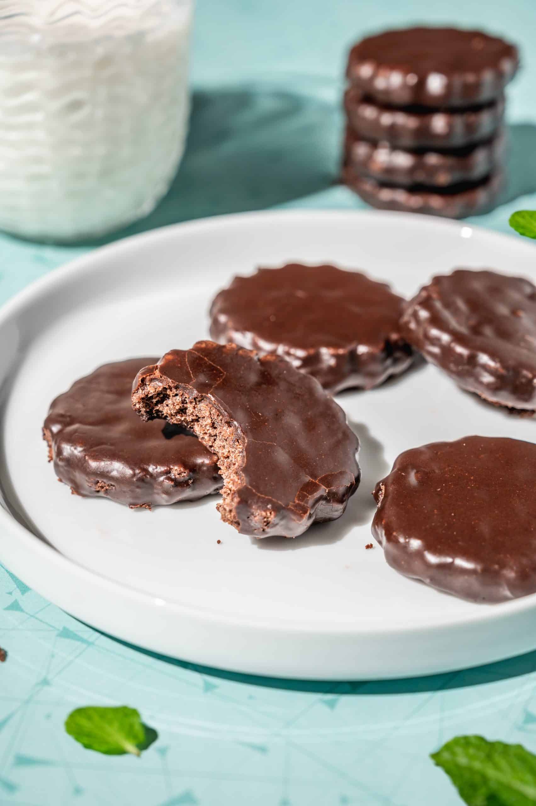 copycat thin mints on a white plate with a glass of milk in the background