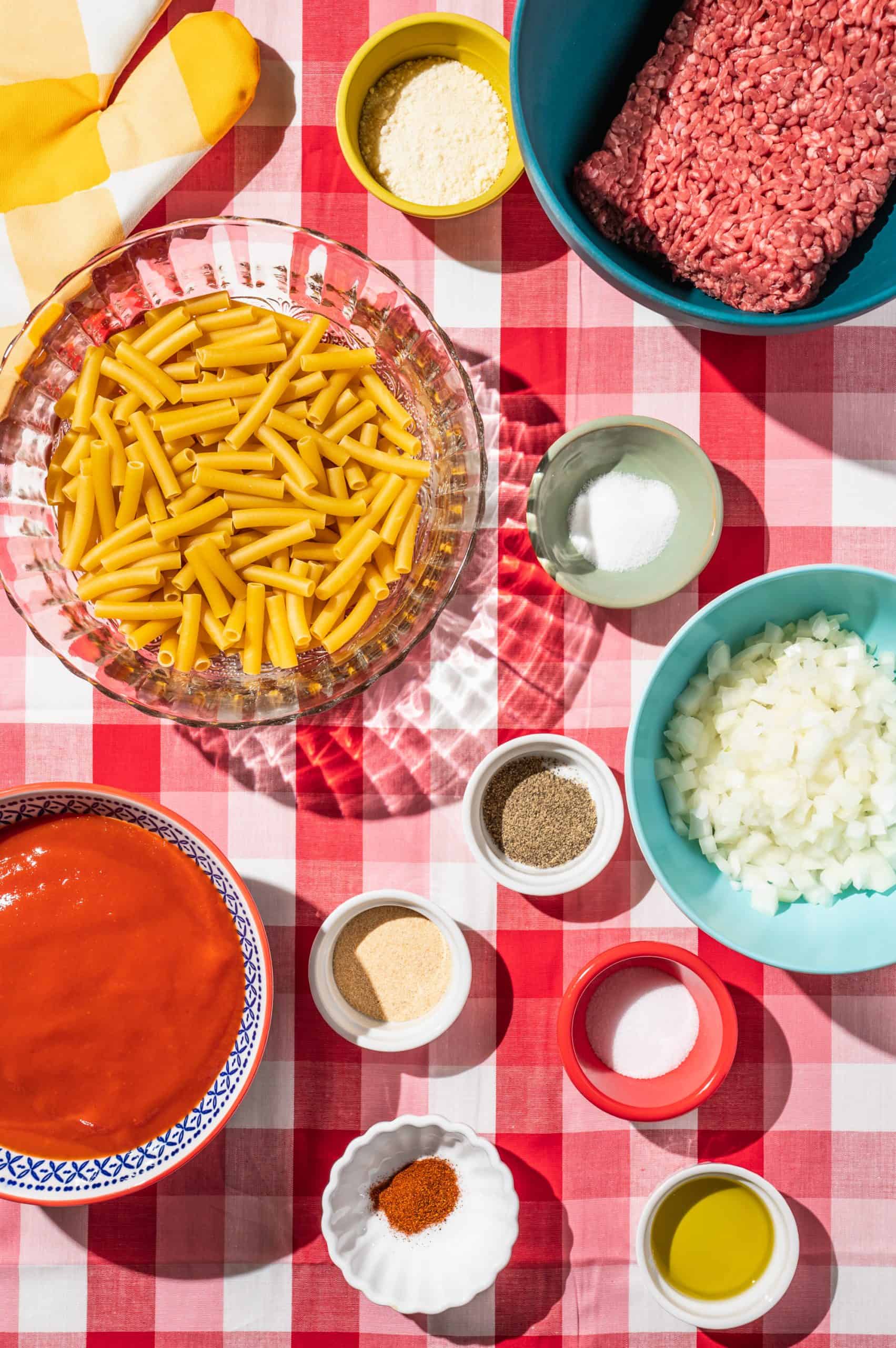 ingredients to make one-pot beefaroni: beef, ziti, onion, tomato soup, and spices