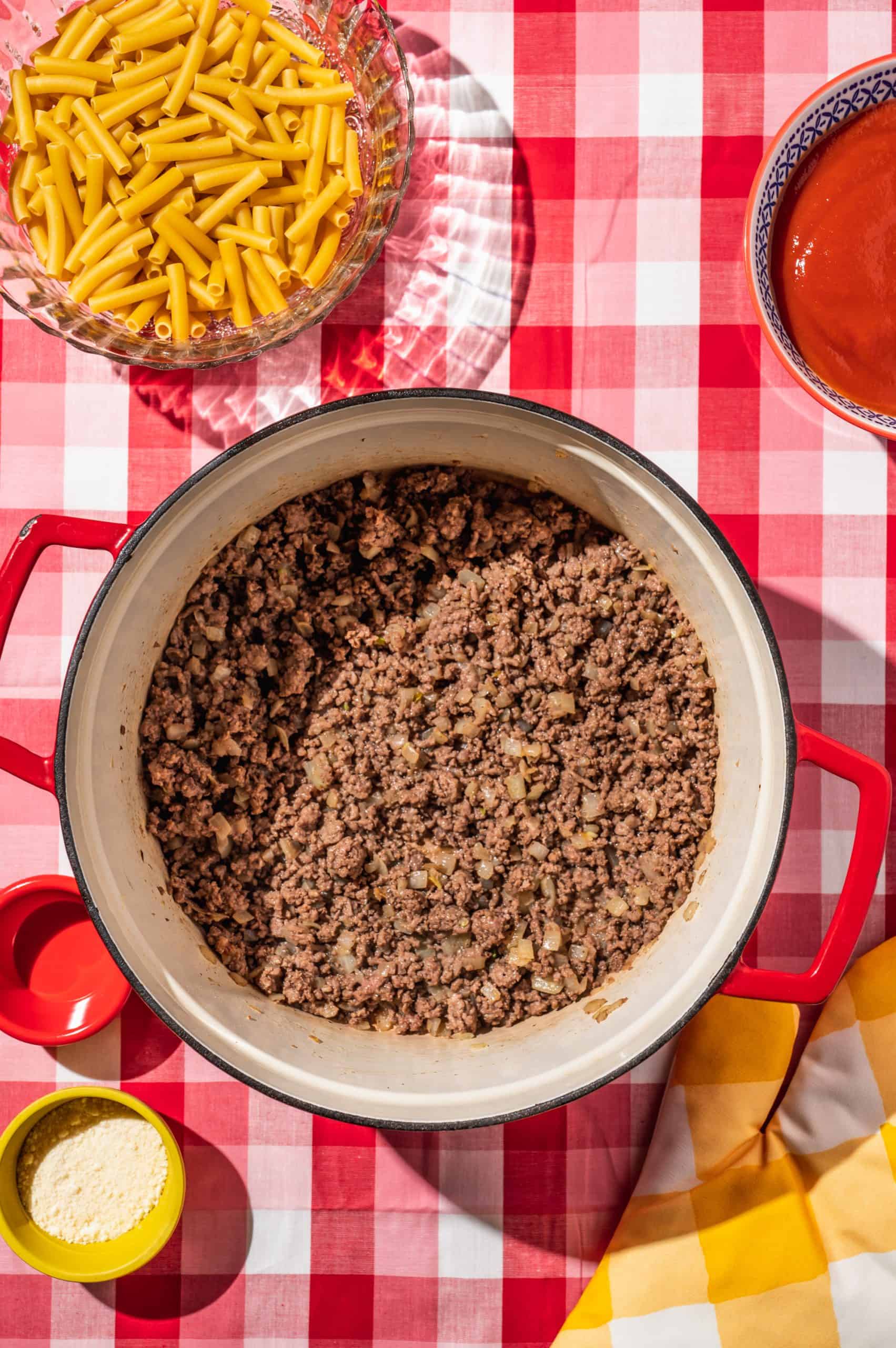 large red Dutch oven with cooked ground beef and onion