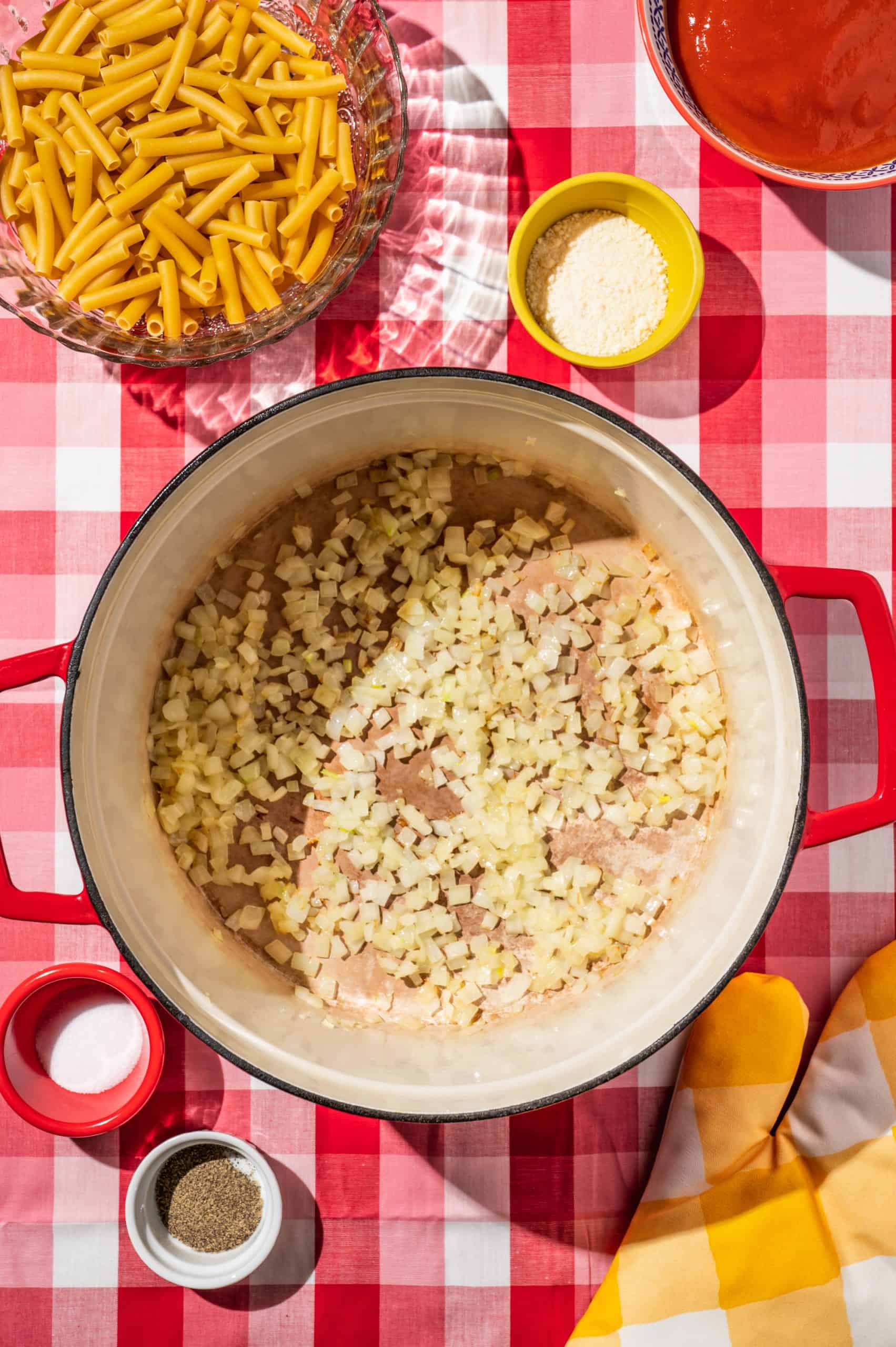 finely chopped onions cooking in a large red pot