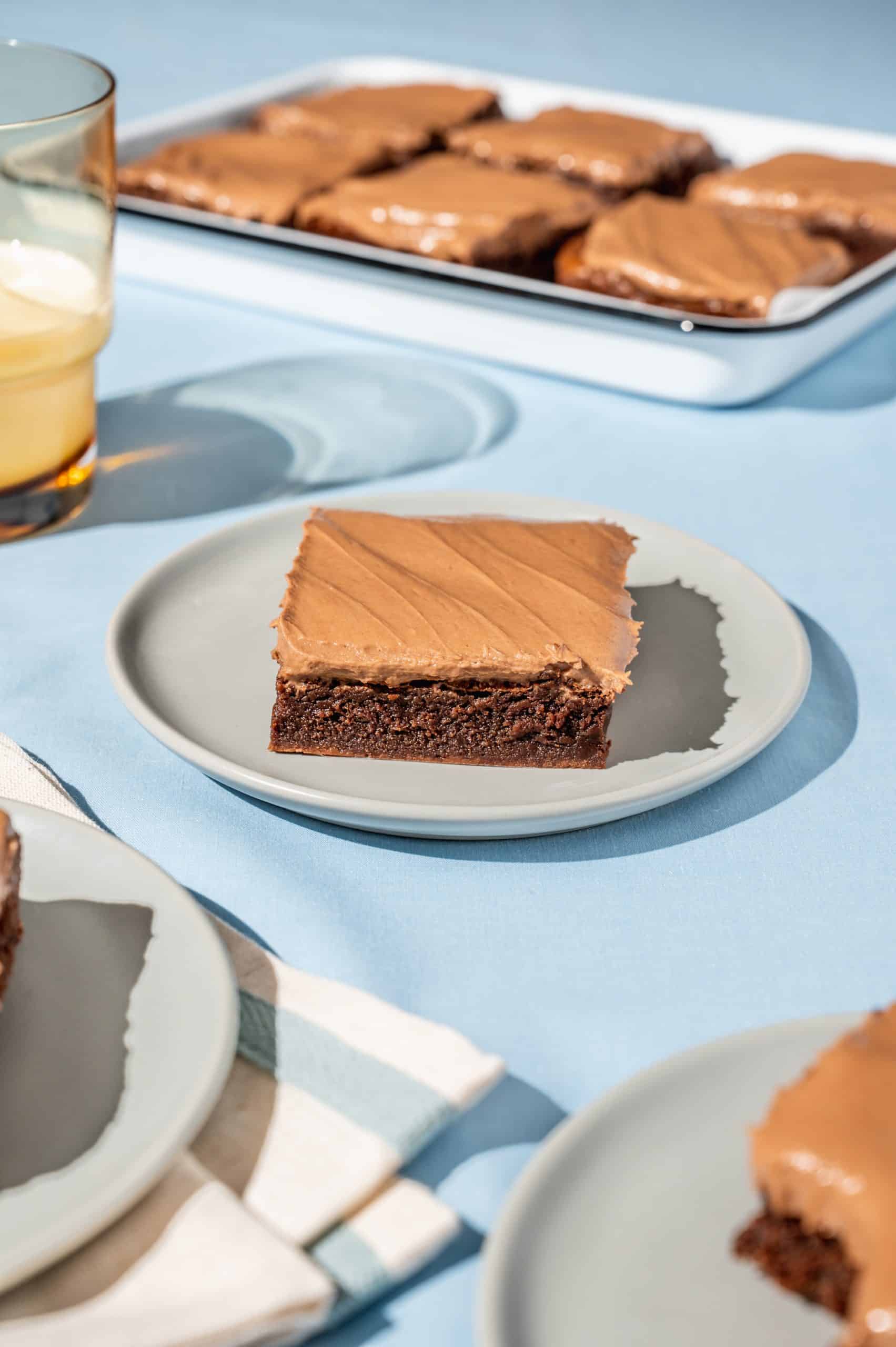 nutella brownie with nutella frosting on a small gray plate on a blue tablecloth