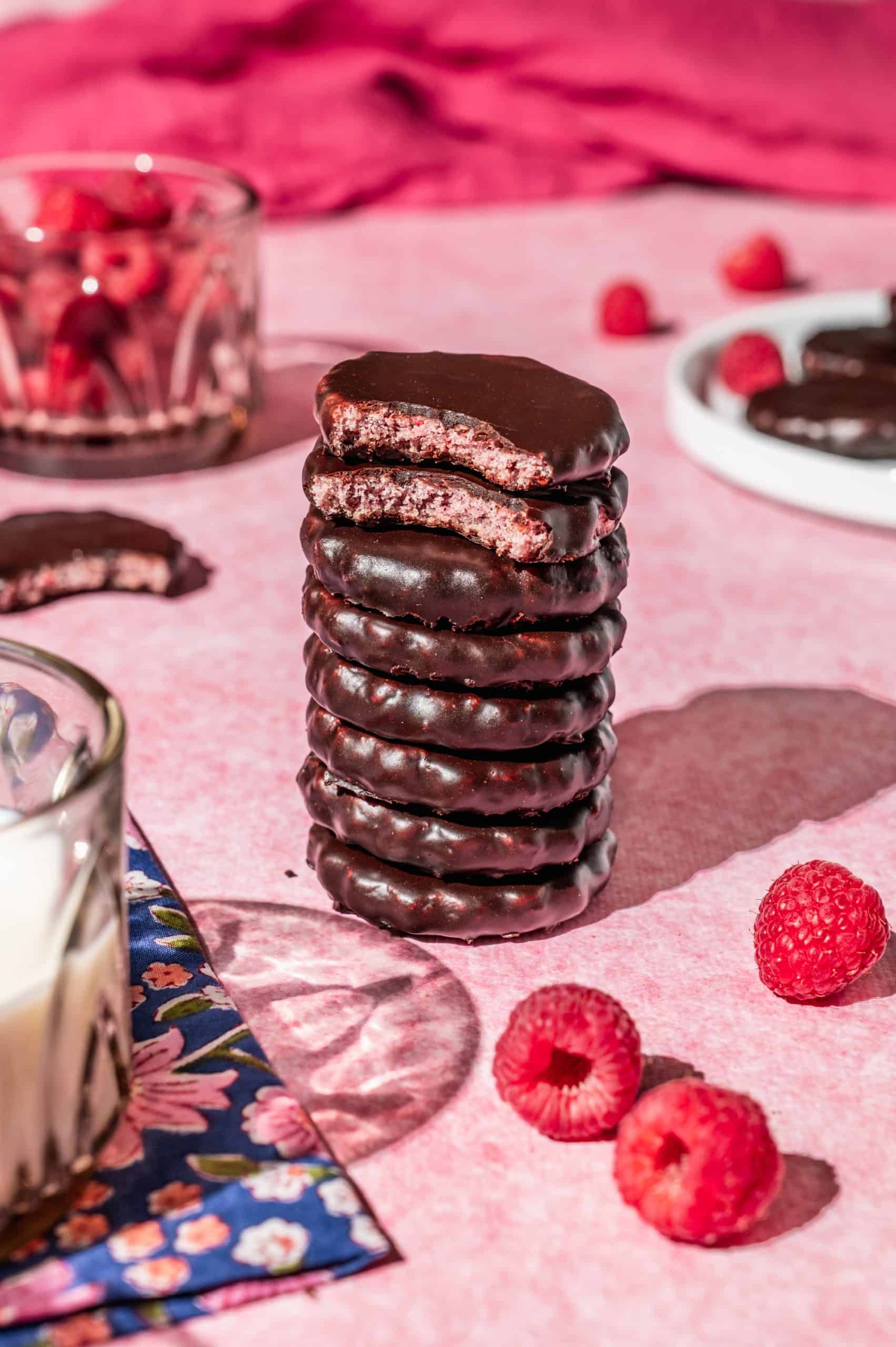 a stack of 8 raspberry rally cookies, the top 2 show the pink cookie inside the chocolate coating