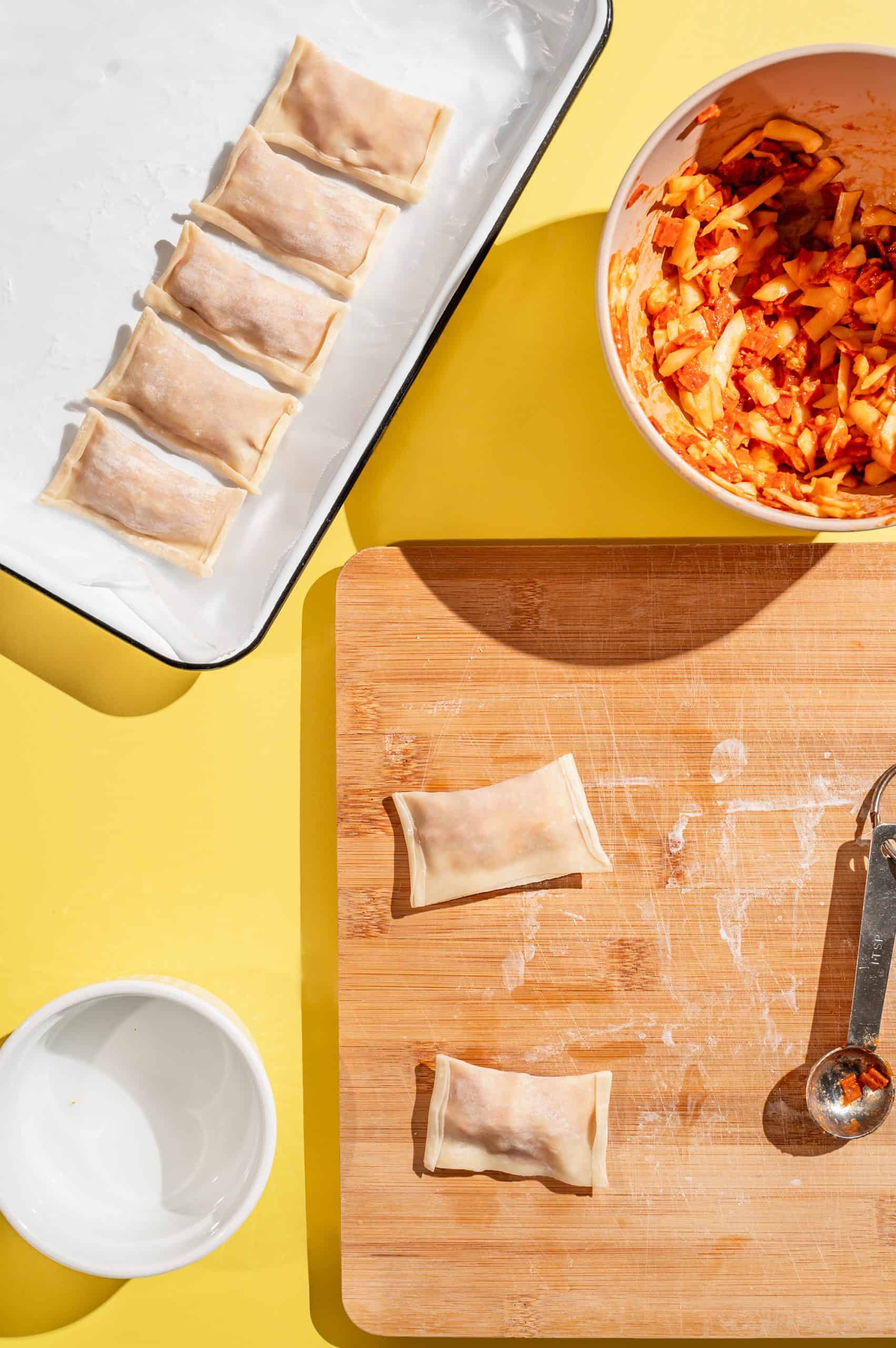 egg roll wrapper folded over the pizza roll filling and sealed with water on the two short edges