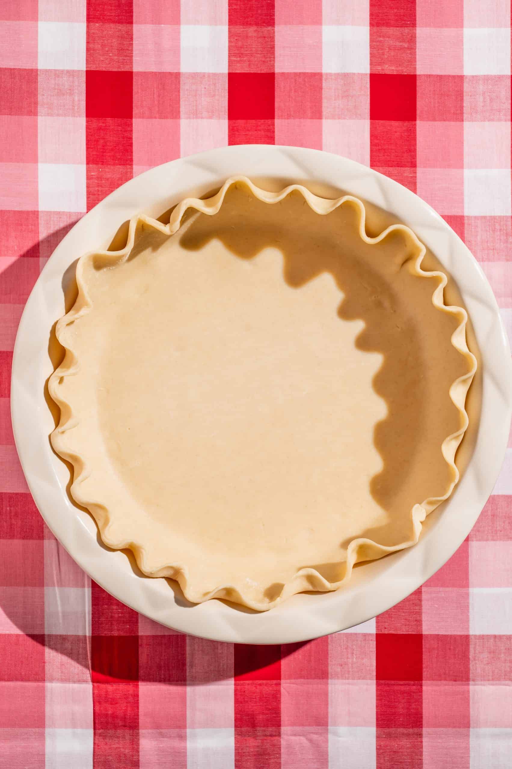 pie dough rolled out into a pie pan with fluted edges