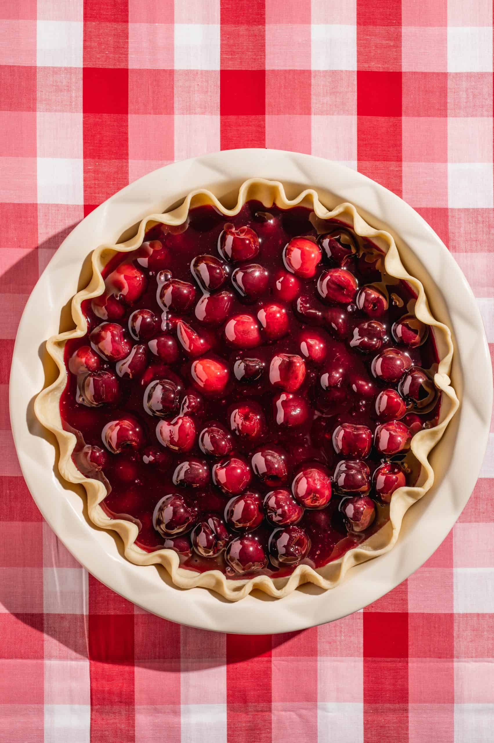raw pie crust filled with homemade cherry pie filling