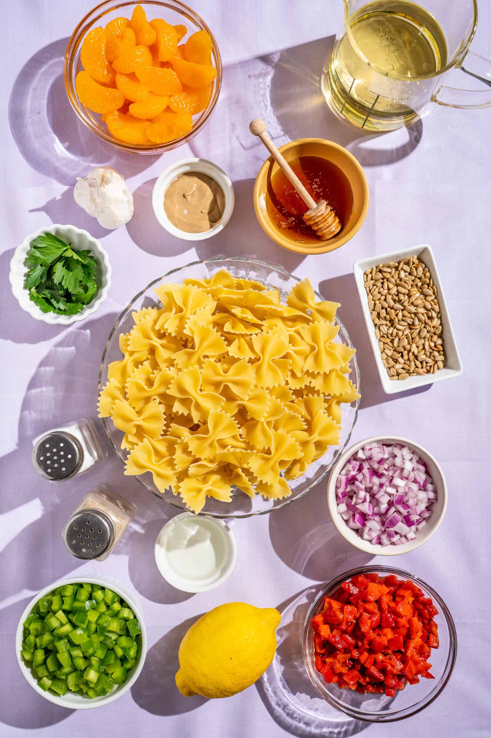 Ingredients for honey pasta salad recipe: pasta, vegetables, lemon juice, herbs, honey, mandarin orange, oil, sunflower seeds, seasoning.