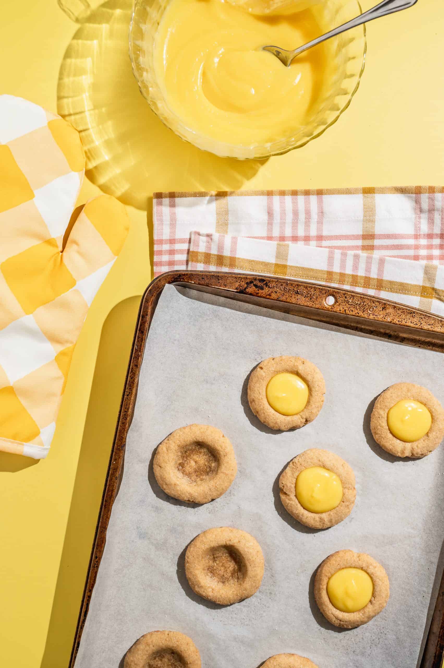 filling warm baked thumbprint cookies with partially set lemon curd