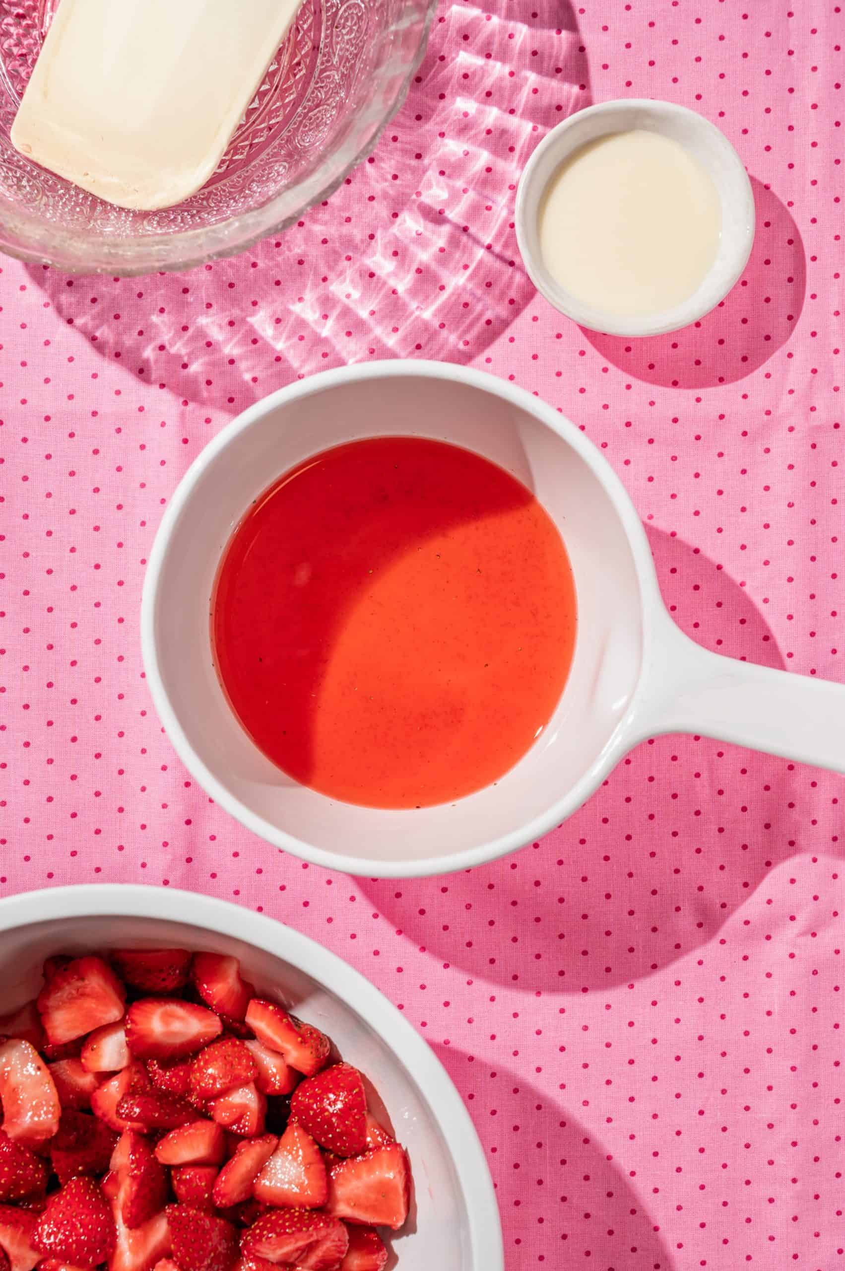 small white pot with strawberry juice and sugar, cornstarch slurry to the side