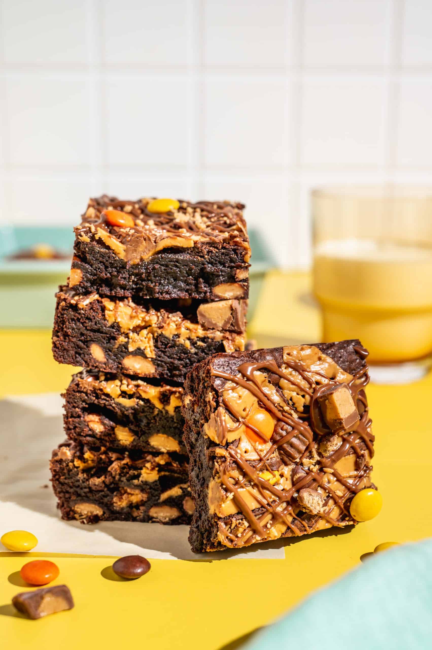A stack of 4 Reeses Pieces brownies with one brownie leaning against the front.