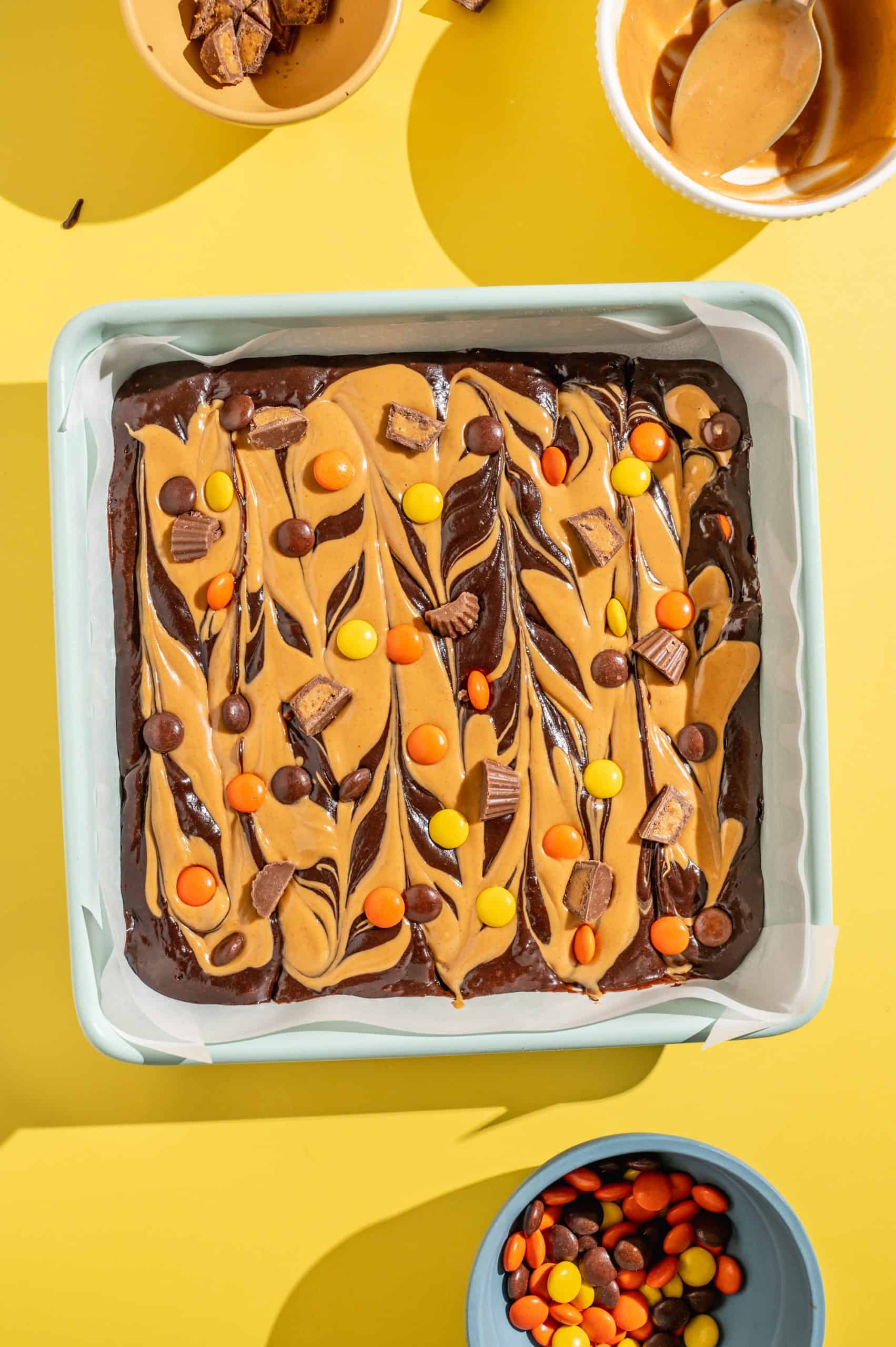 Brownie batter swirled with peanut butter and topped with Reeses candy before baking.