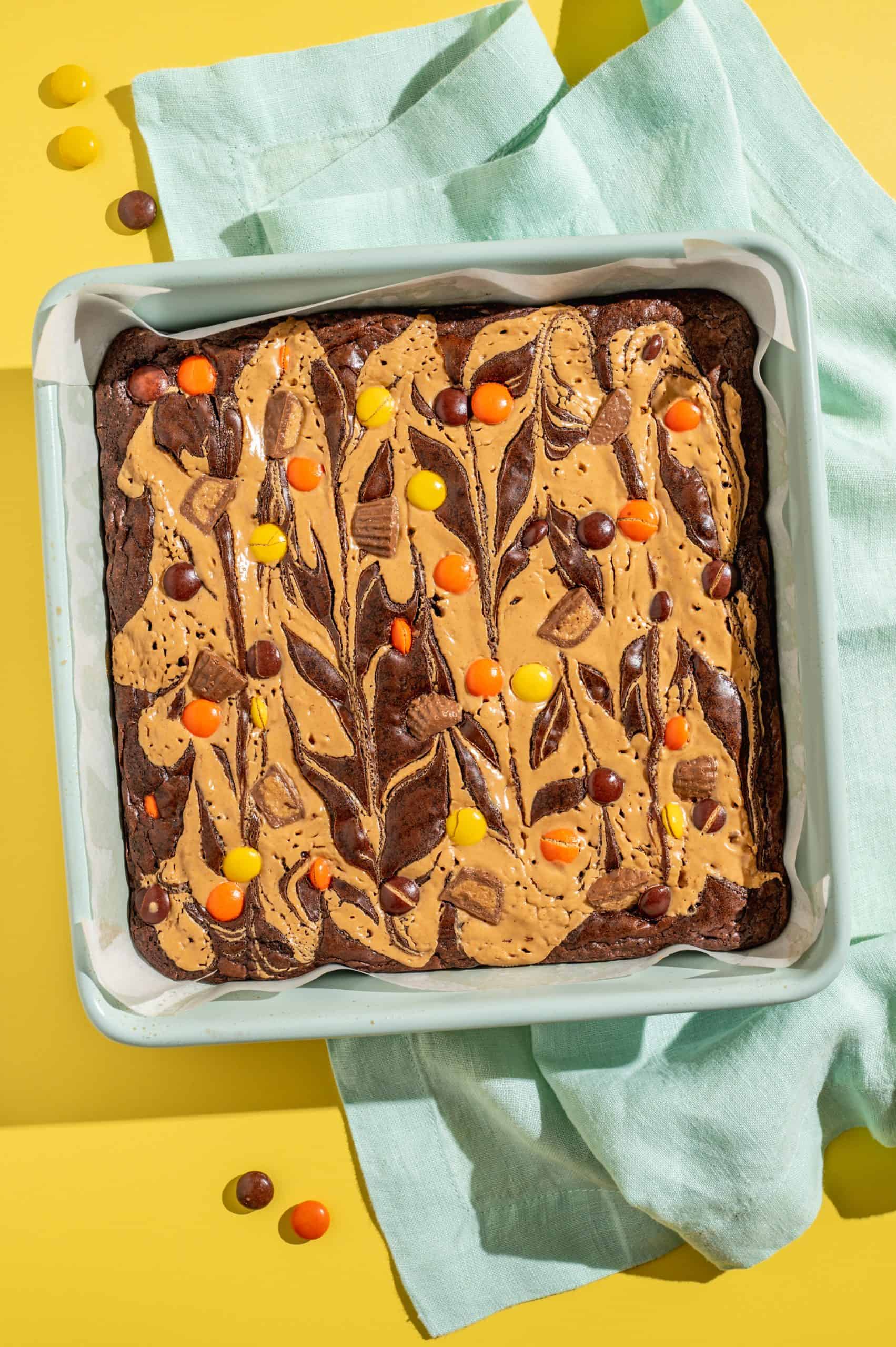 Peanut butter swirled Reese's pieces brownies in a pan after baking.