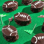 cream-filled mini football cakes on a green turf surface
